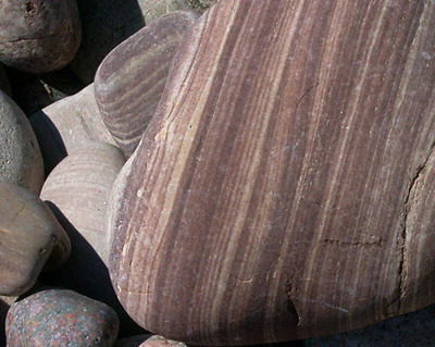 Close-up view of layered, striped rocks with visible textures and striations in Blå Jungfrun National Park.