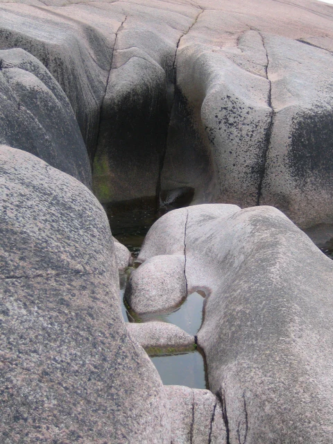 Large gray rock formations with a natural depression filled with water