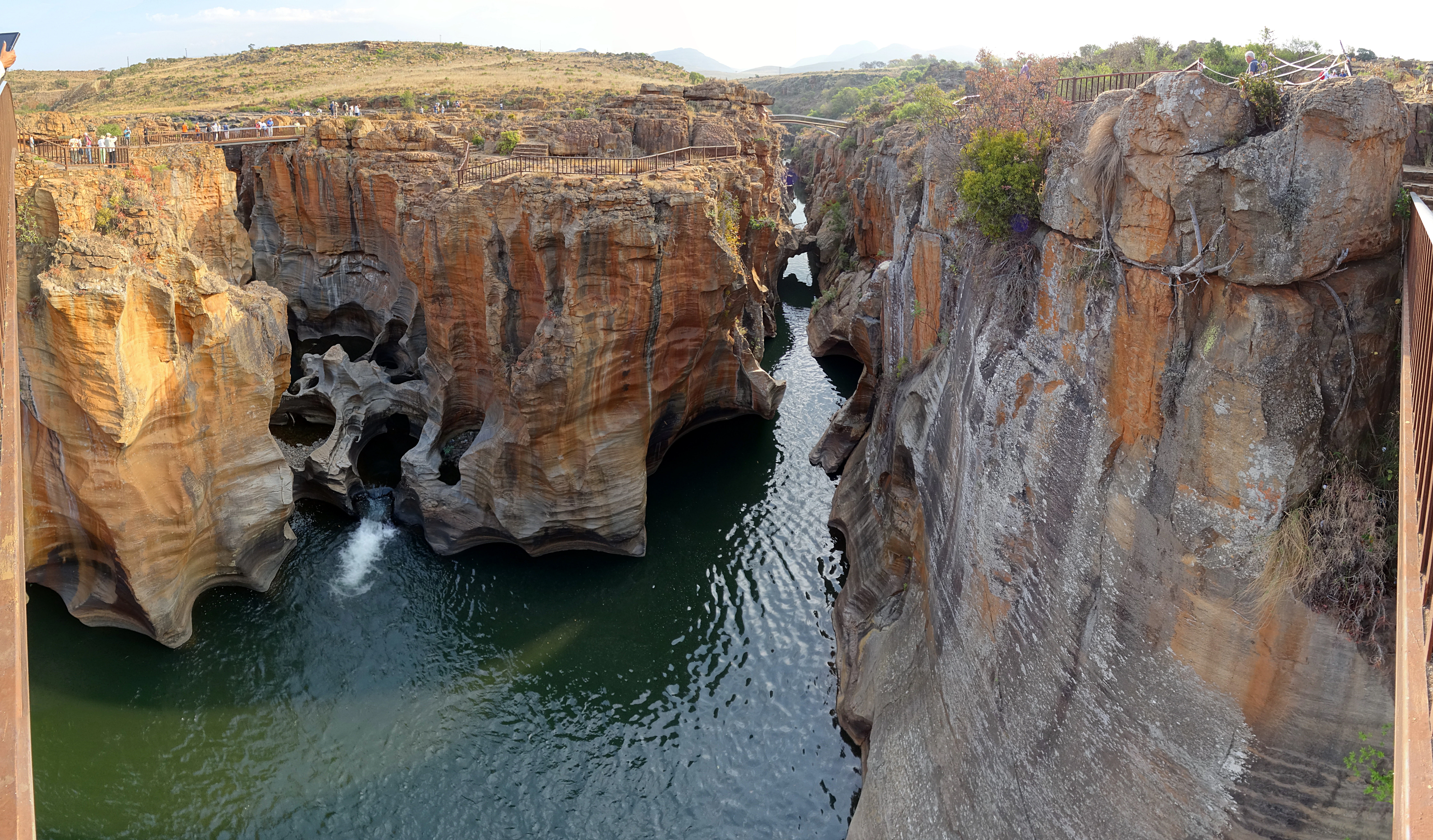 A wide angle view of the deep, carved rock formations known as Bourke's Luck Potholes, where the Blyde River flows through a narrow, steep-sided canyon.