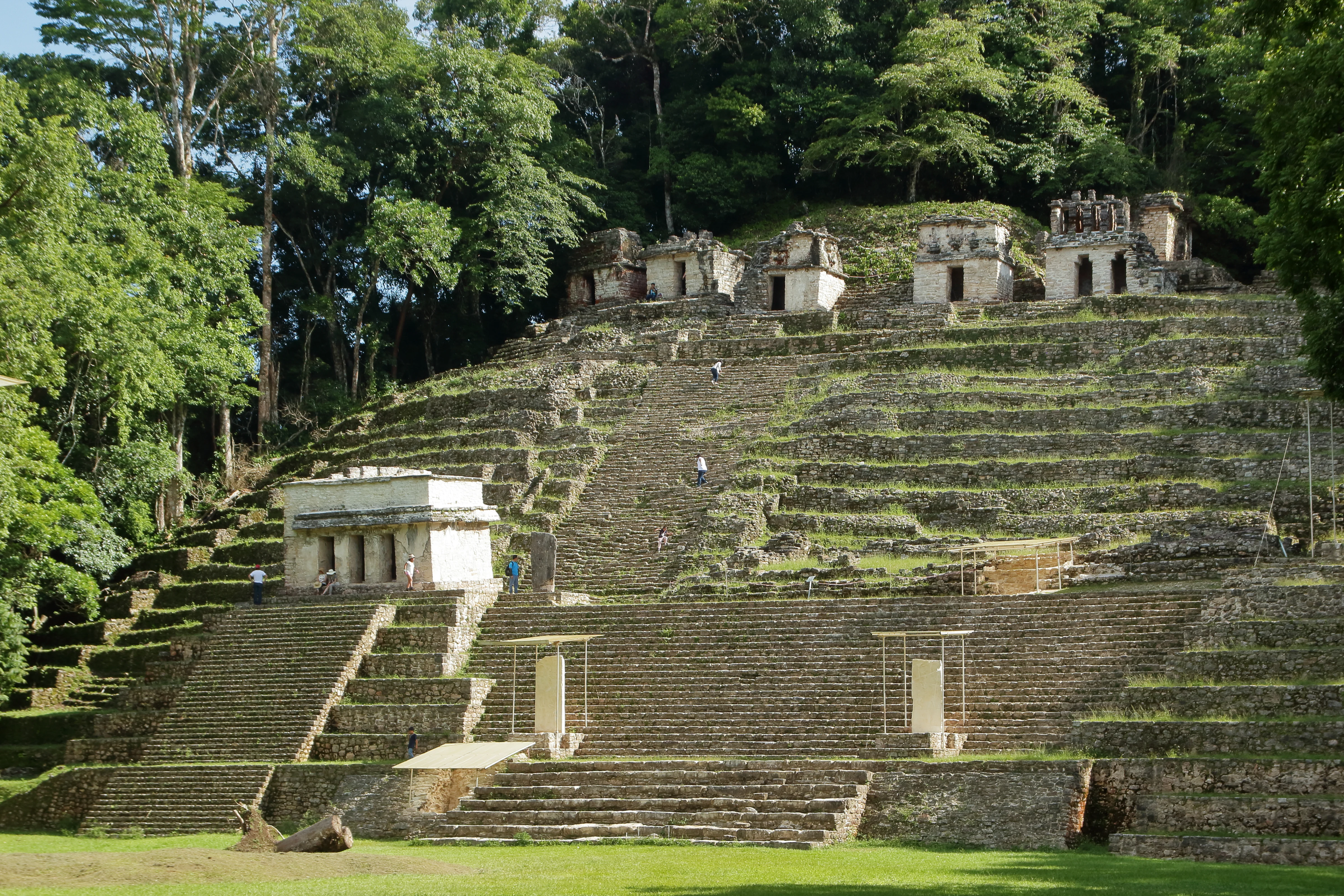 A wide shot of a multi-tiered Mayan stone pyramid at Bonampak, surrounded by dense jungle.