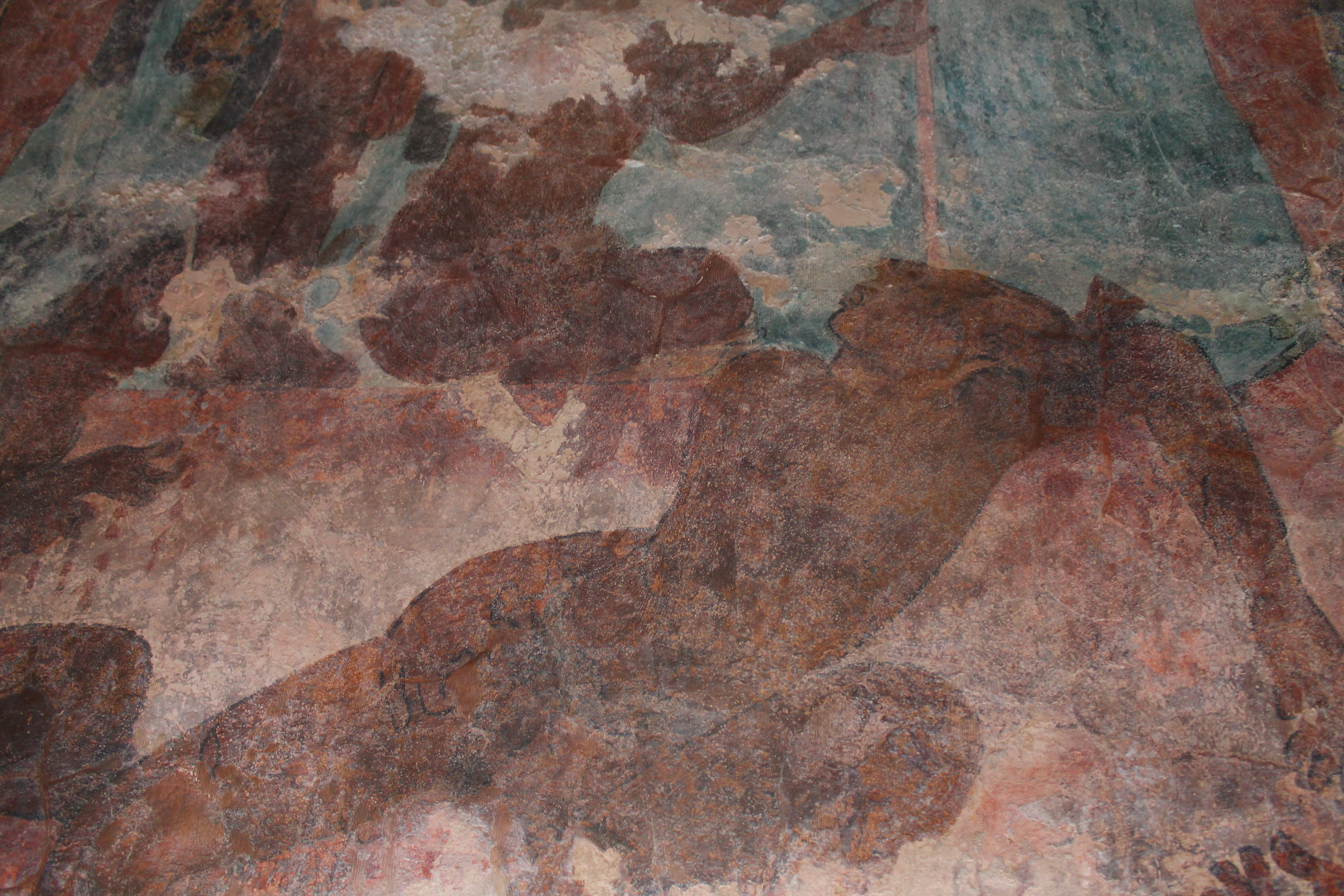 Ancient Maya mural painting showing a stylized, reclining human figure painted in earthy tones on an aged stone wall.