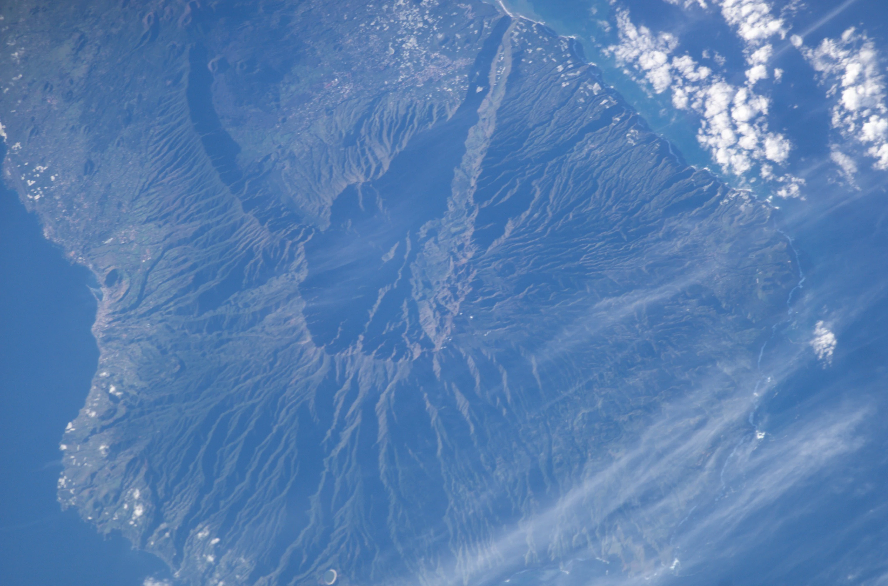 Satellite image showing volcanic caldera, mountain ridges, and coastal terrain of Caldera de Taburiente National Park on La Palma, Canary Islands