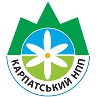 Green mountain peaks, blue and green circular background with white flower, and Cyrillic text 'КАРПАТСЬКИЙ НПП' on emblem