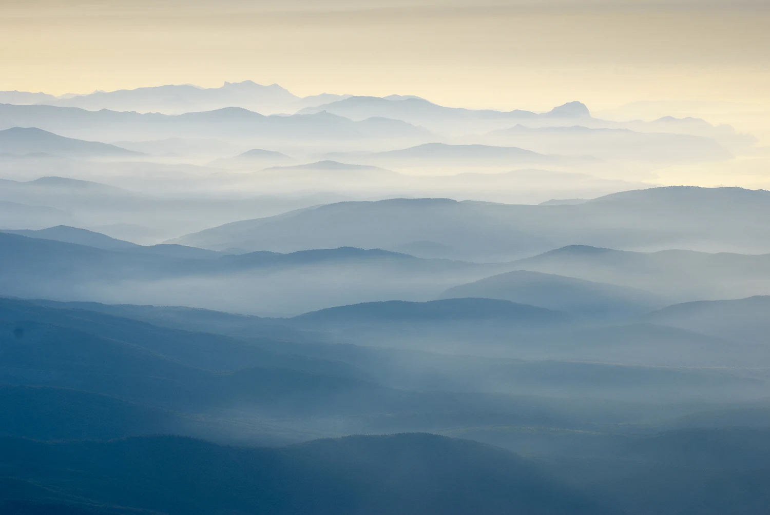 Layered blue mountain ridges receding into the distance under a misty sky.