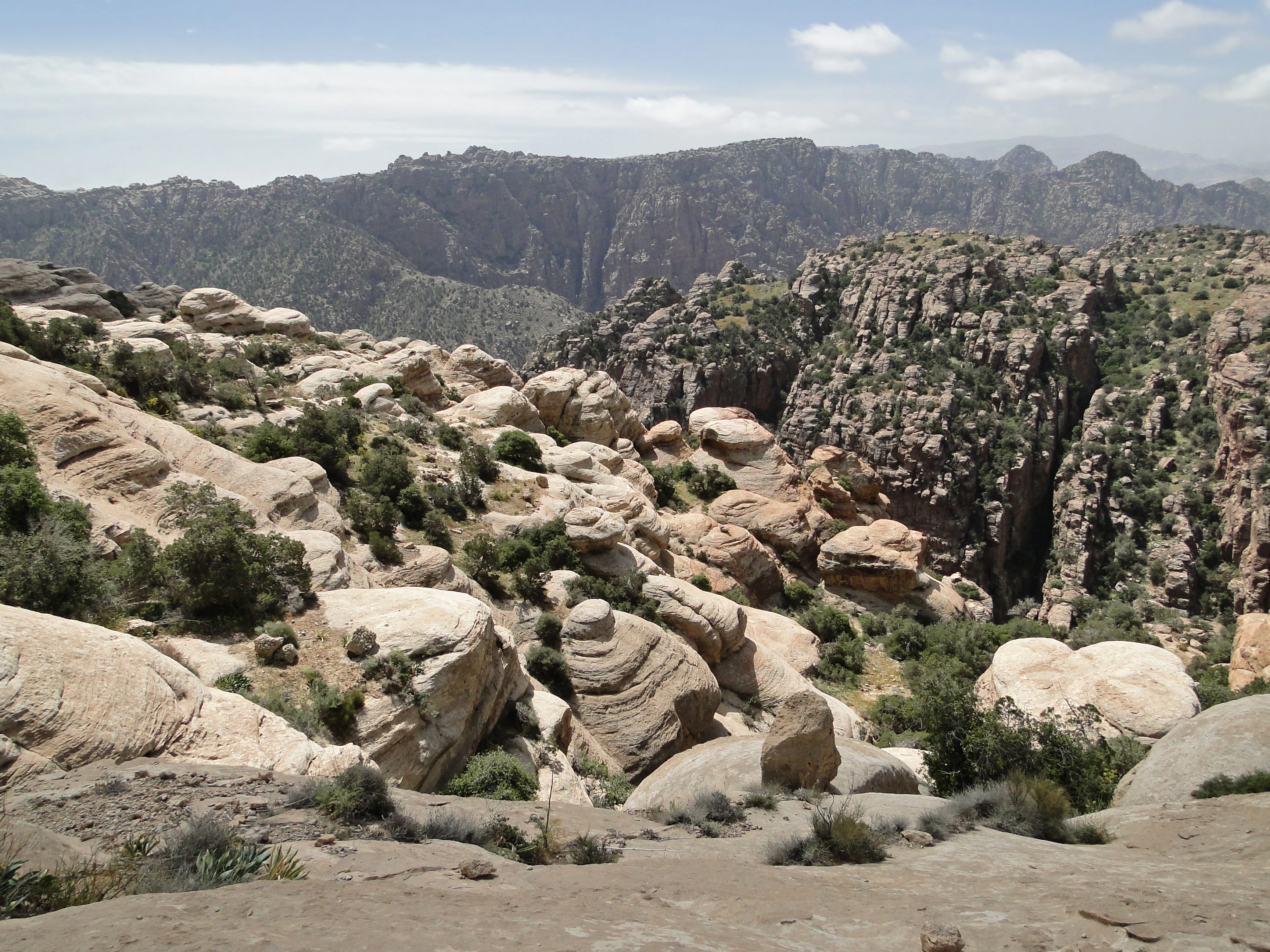 Rocky landscape with large boulders and steep cliffs in a mountainous valley