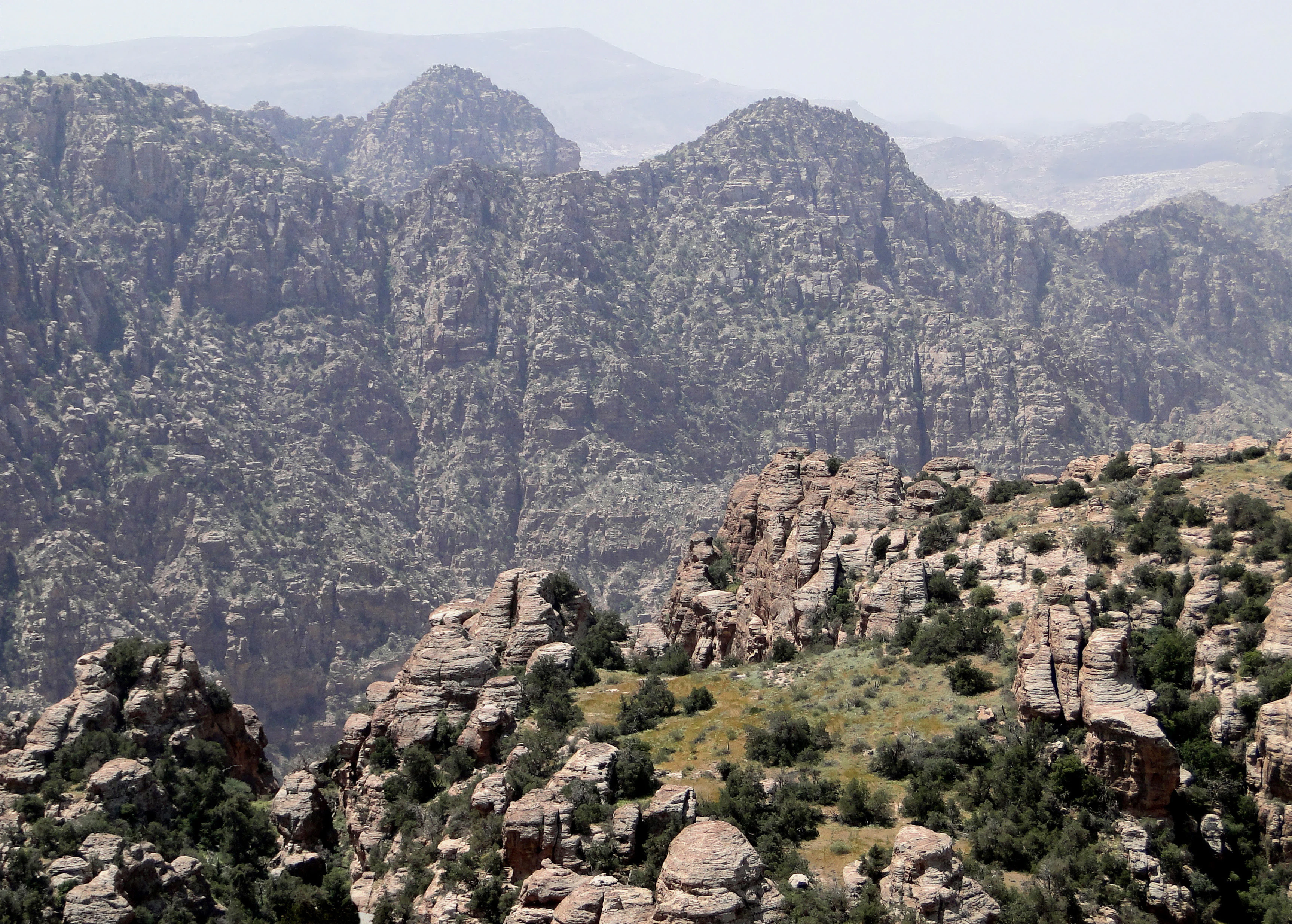 Rocky mountain landscape with steep cliffs and scattered vegetation in Dana Biosphere Reserve
