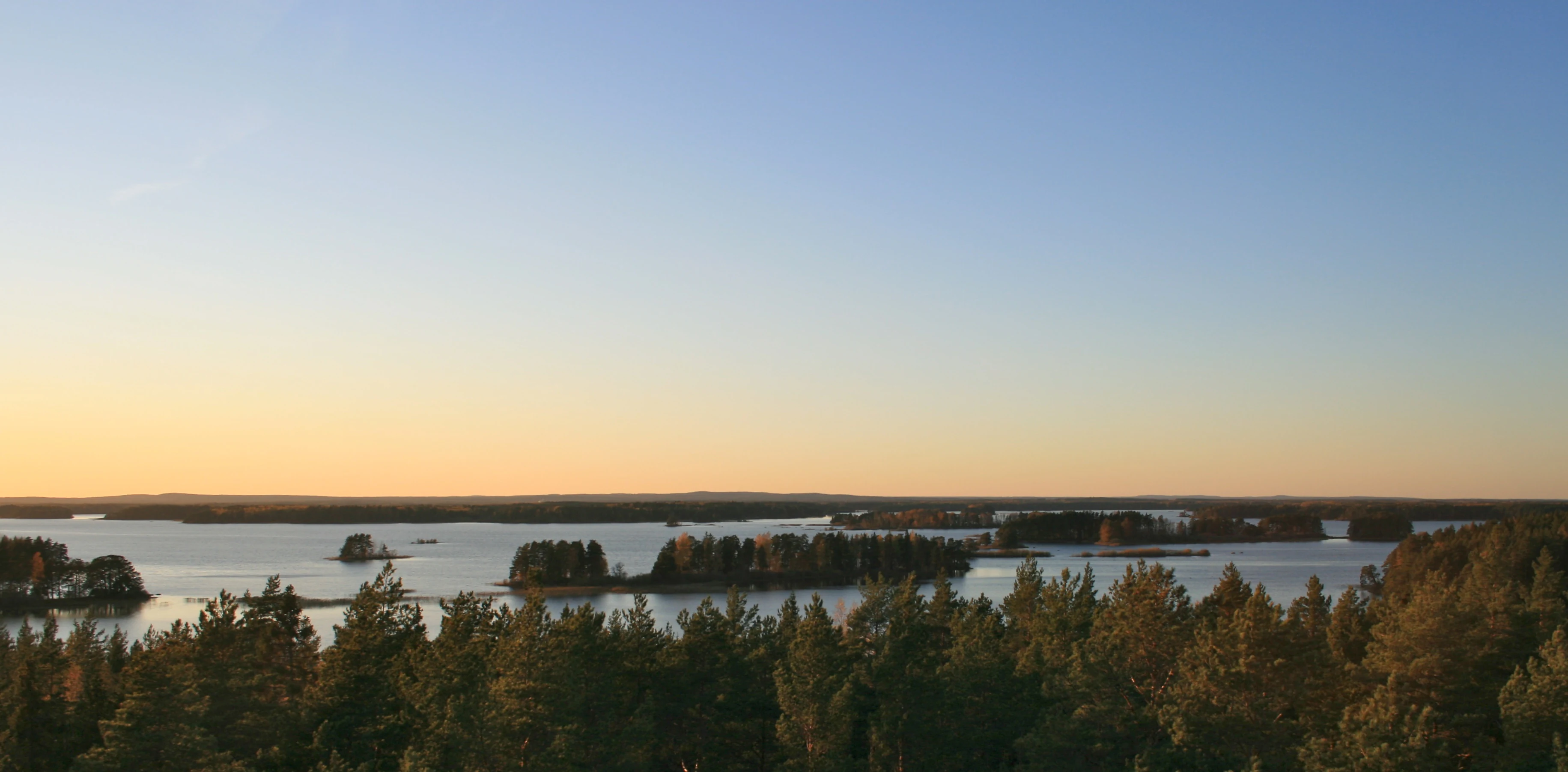 River with numerous small islands and dense forests under a clear sky