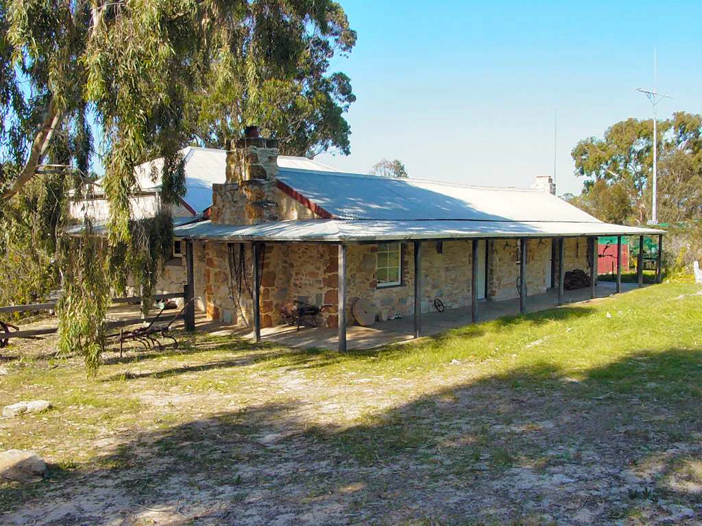 Stone building with metal roof, covered porch, and surrounding trees in Fitzgerald River National Park