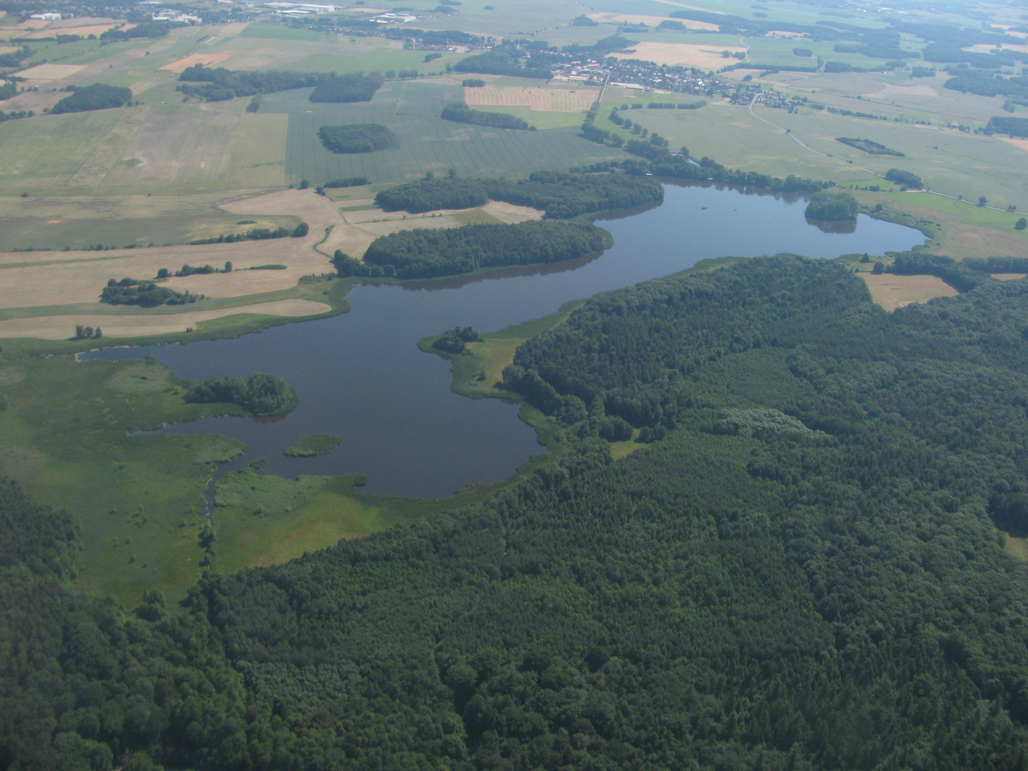 An aerial view showing the Frauenteich pond surrounded by forests and agricultural fields.