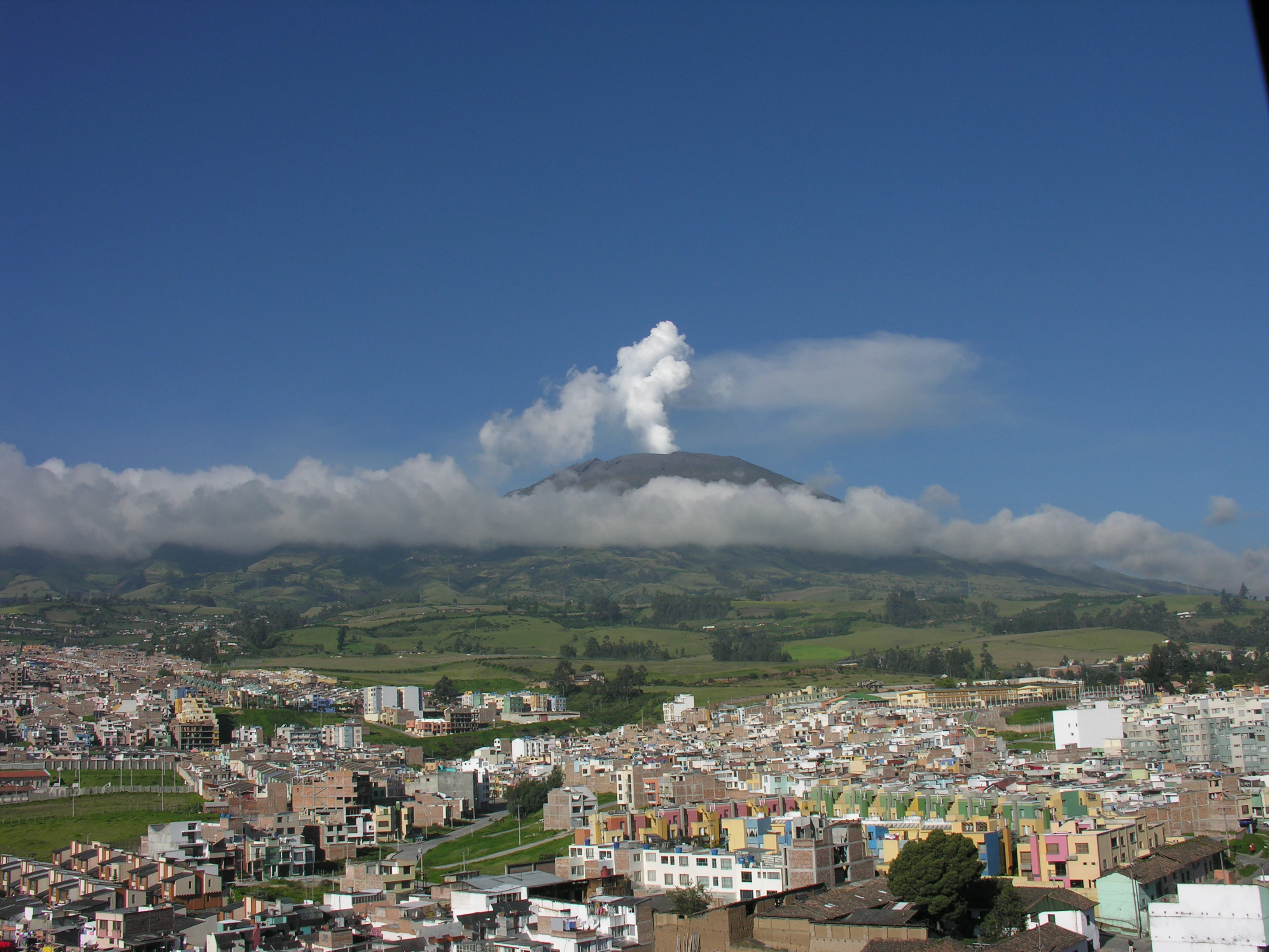 Galeras Volcano with smoke emission above the city of Pasto under a clear blue sky