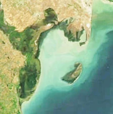 Una vista satelital cenital que muestra la costa, las aguas poco profundas de la bahía y las áreas terrestres de la Reserva Estatal de Ghizil-Agaj a lo largo del mar Caspio.