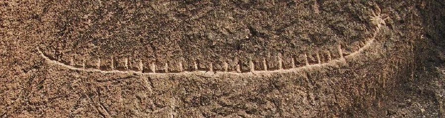 Una vista en primer plano de un antiguo petroglifo de una embarcación tallado en una superficie de piedra rugosa y erosionada, con un detalle de estrella de ocho puntas visible en la proa.