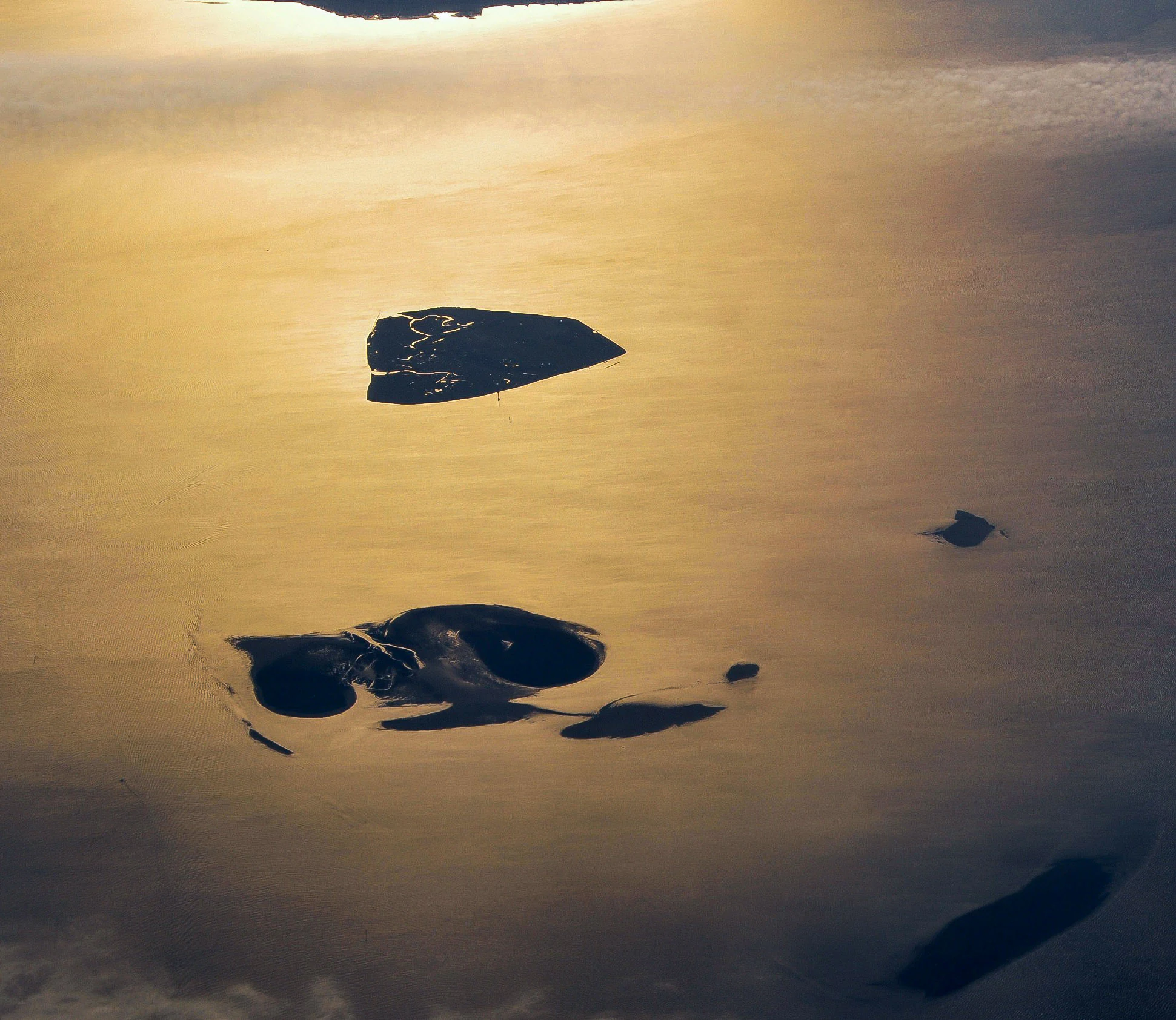Aerial view of small islands and tidal mudflats in the Hamburg Wadden Sea National Park during sunset