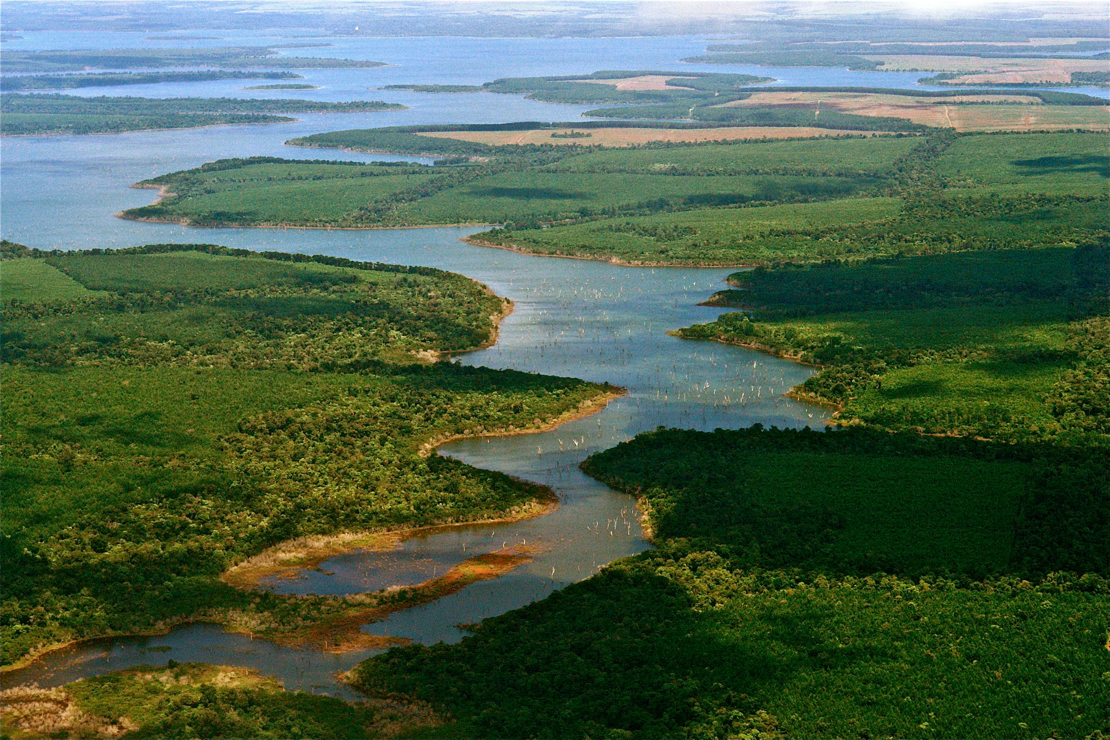 An aerial view showing a winding waterway surrounded by green vegetation and marshy islands in the Iberá Wetlands.