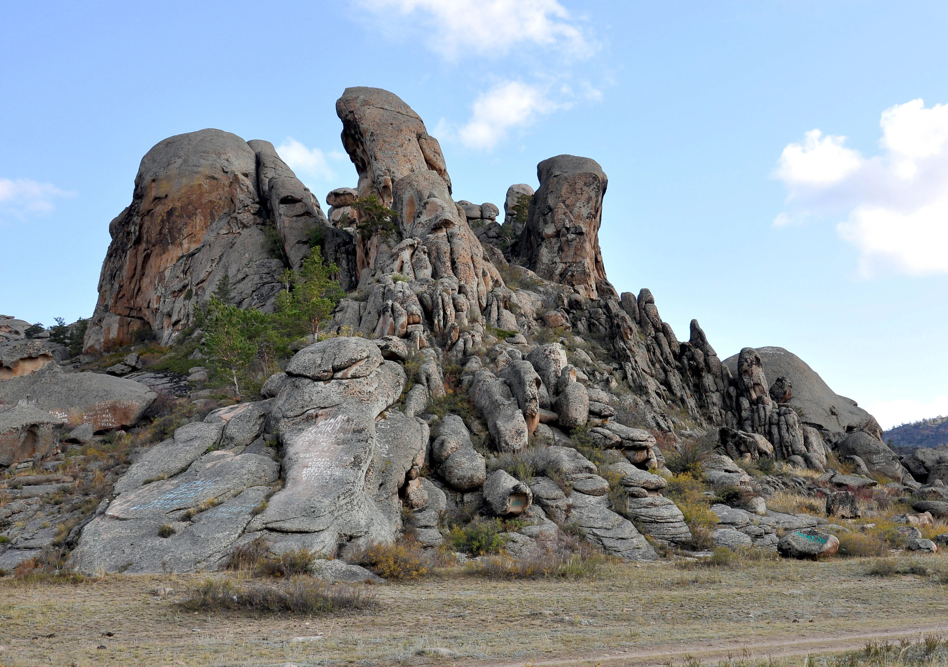 Rock formations on a mountain slope under a partly cloudy sky