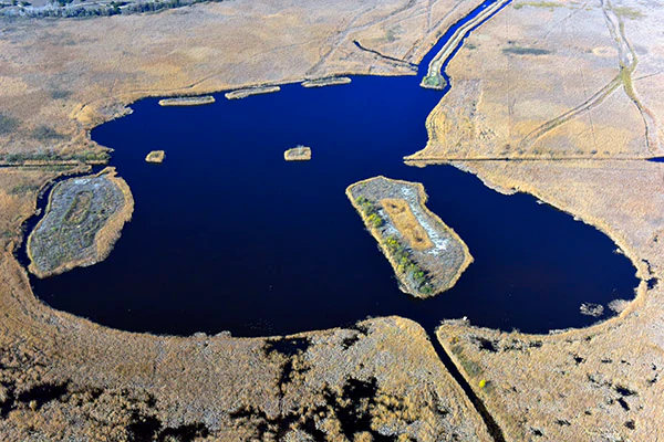 Aerial view of Kolon Lake with surrounding wetlands and grasslands, showing islands and water channels