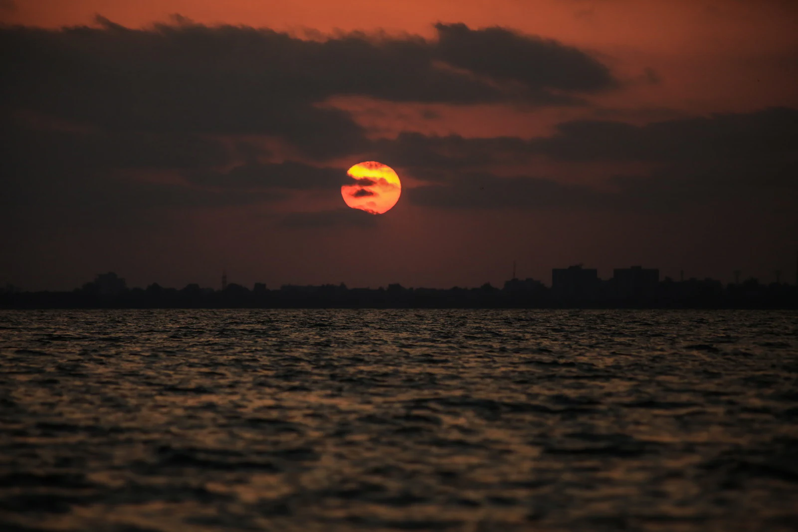 Sunset over water with a city skyline in the background