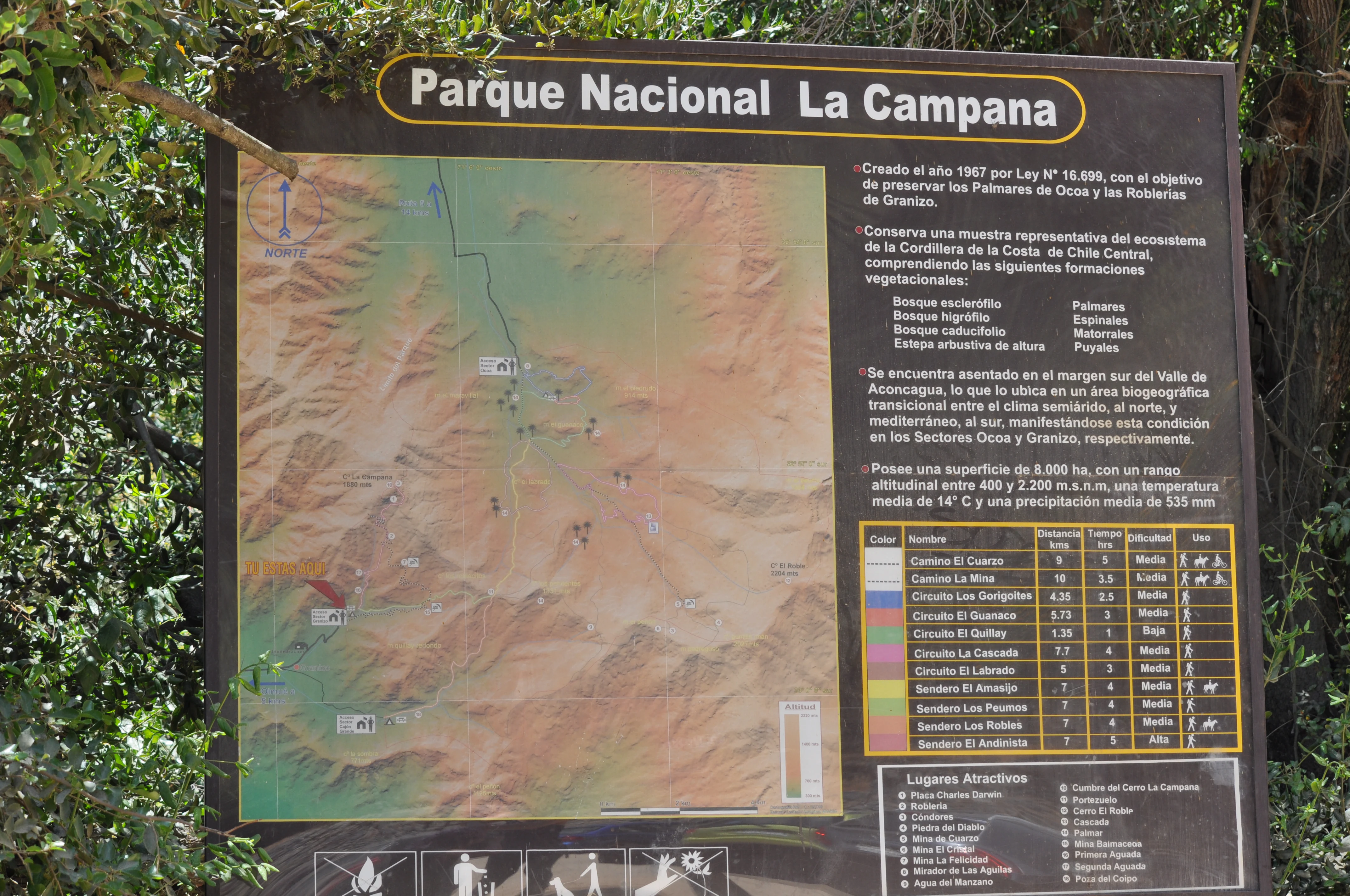 Black signboard displaying map, text, and legend for Parque Nacional La Campana with park details and topographic information