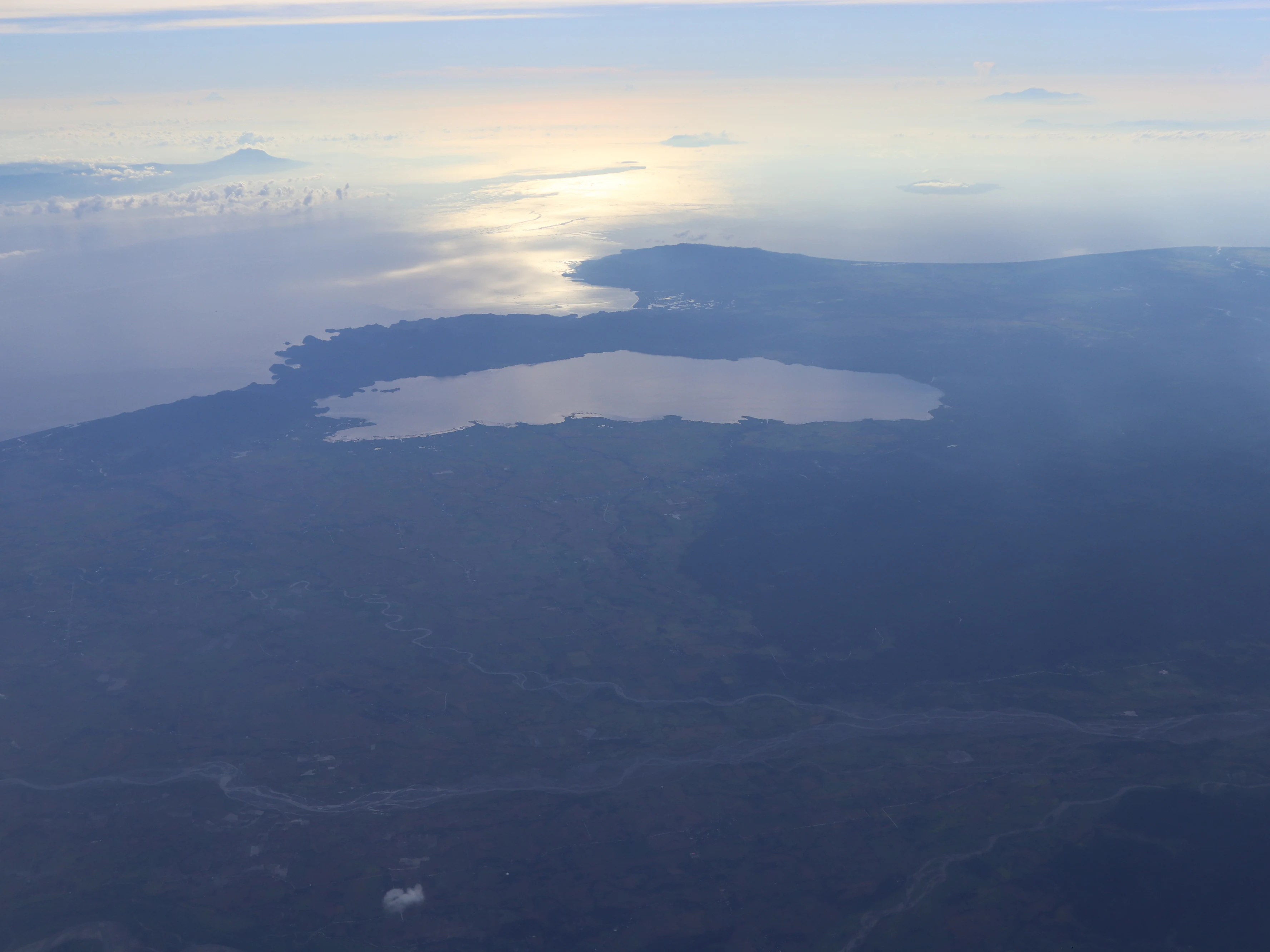 Aerial view looking over Lake Naujan in the Philippines with sun glint on the water surface.