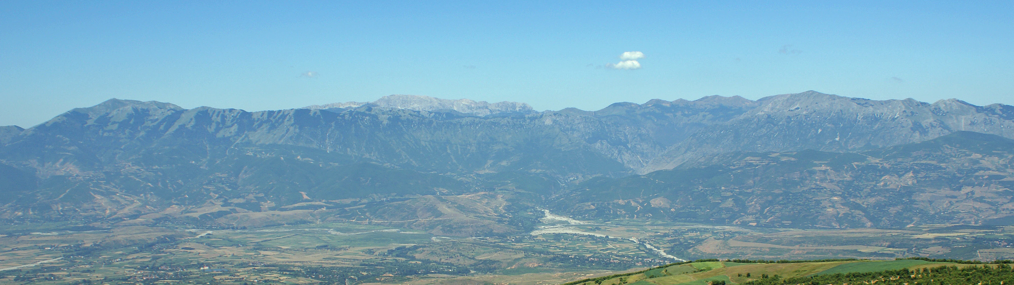 Wide panoramic view of mountain ranges with valleys and a clear blue sky in Lurë-Dejë National Park