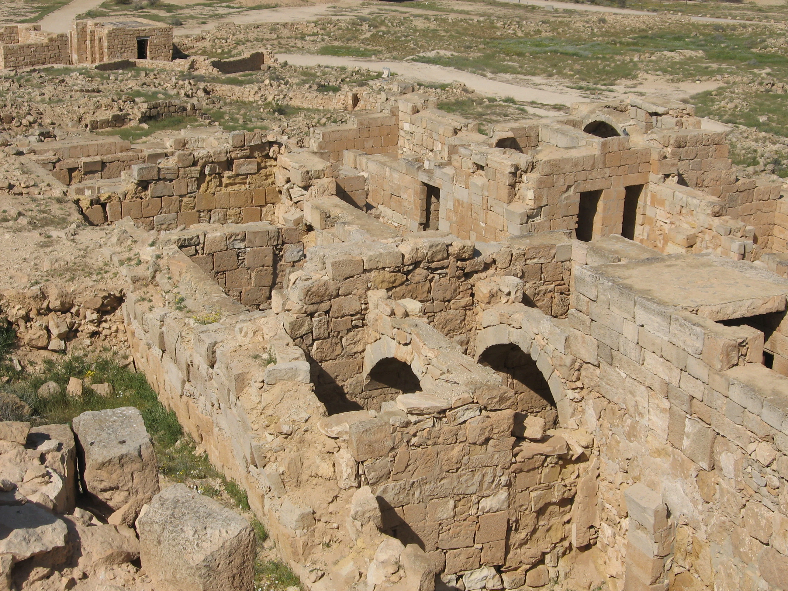 Ruinas de piedra antiguas en el Parque Nacional de Mamshit que muestran muros desgastados, aberturas arqueadas y terreno rocoso en un paisaje árido