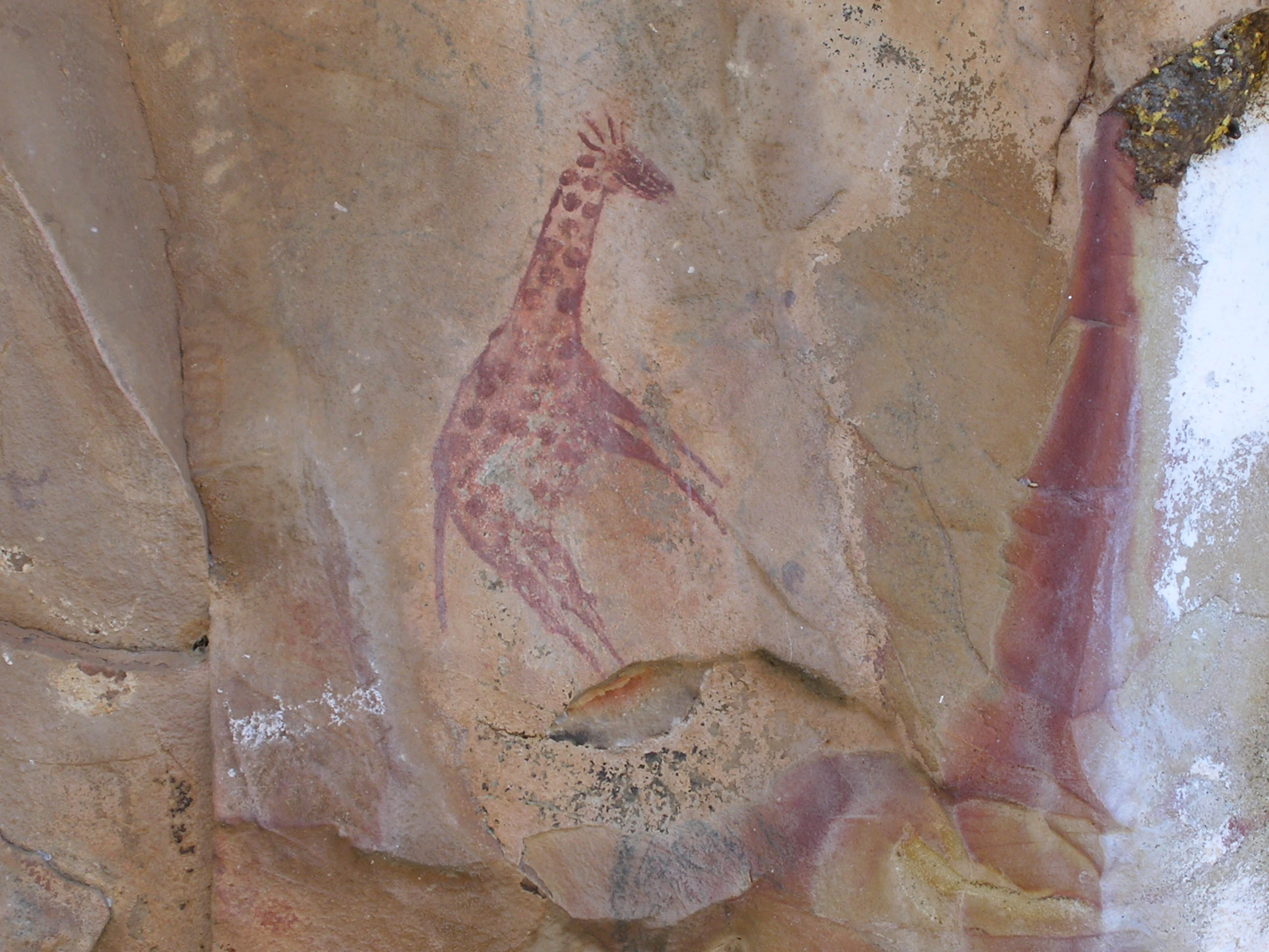 Pared rocosa con arte de jirafa pintado de rojo, parte del Paisaje Cultural de Mapungubwe