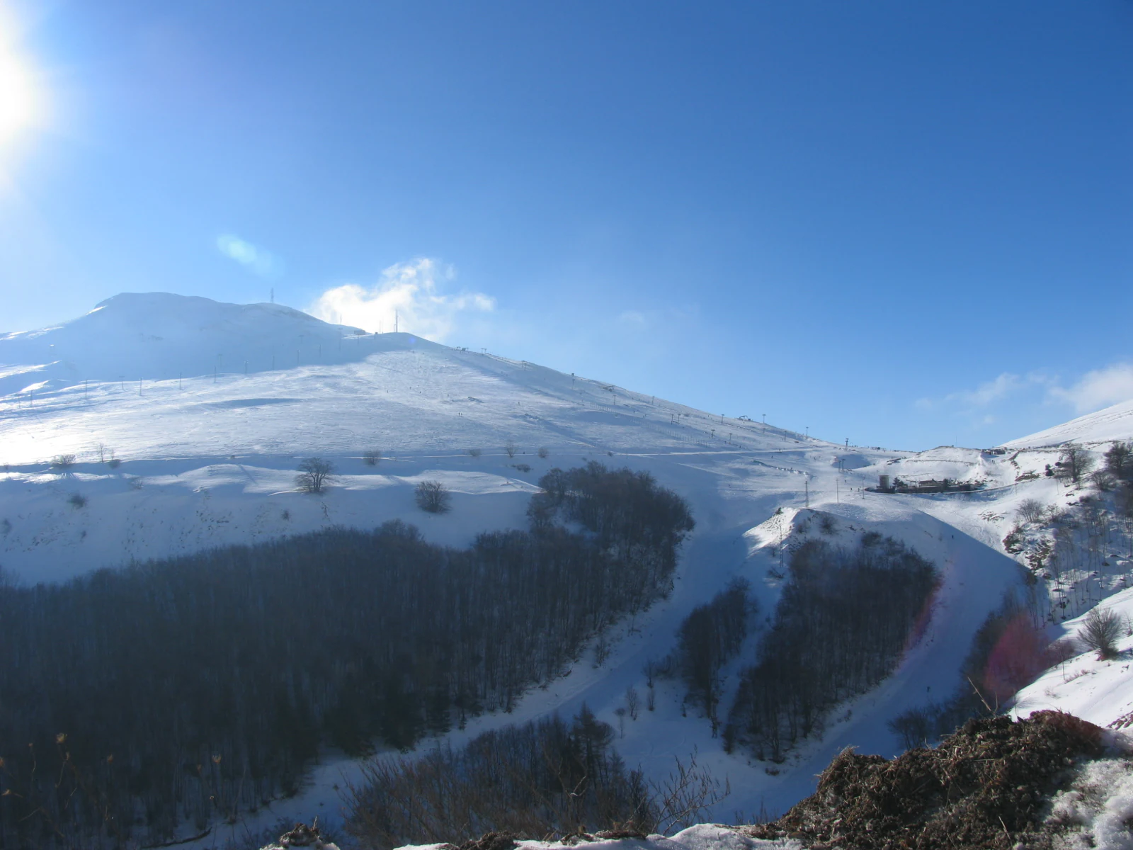 Snow-capped mountain peaks with clear blue sky, showing the Sibillini Mountains in winter.