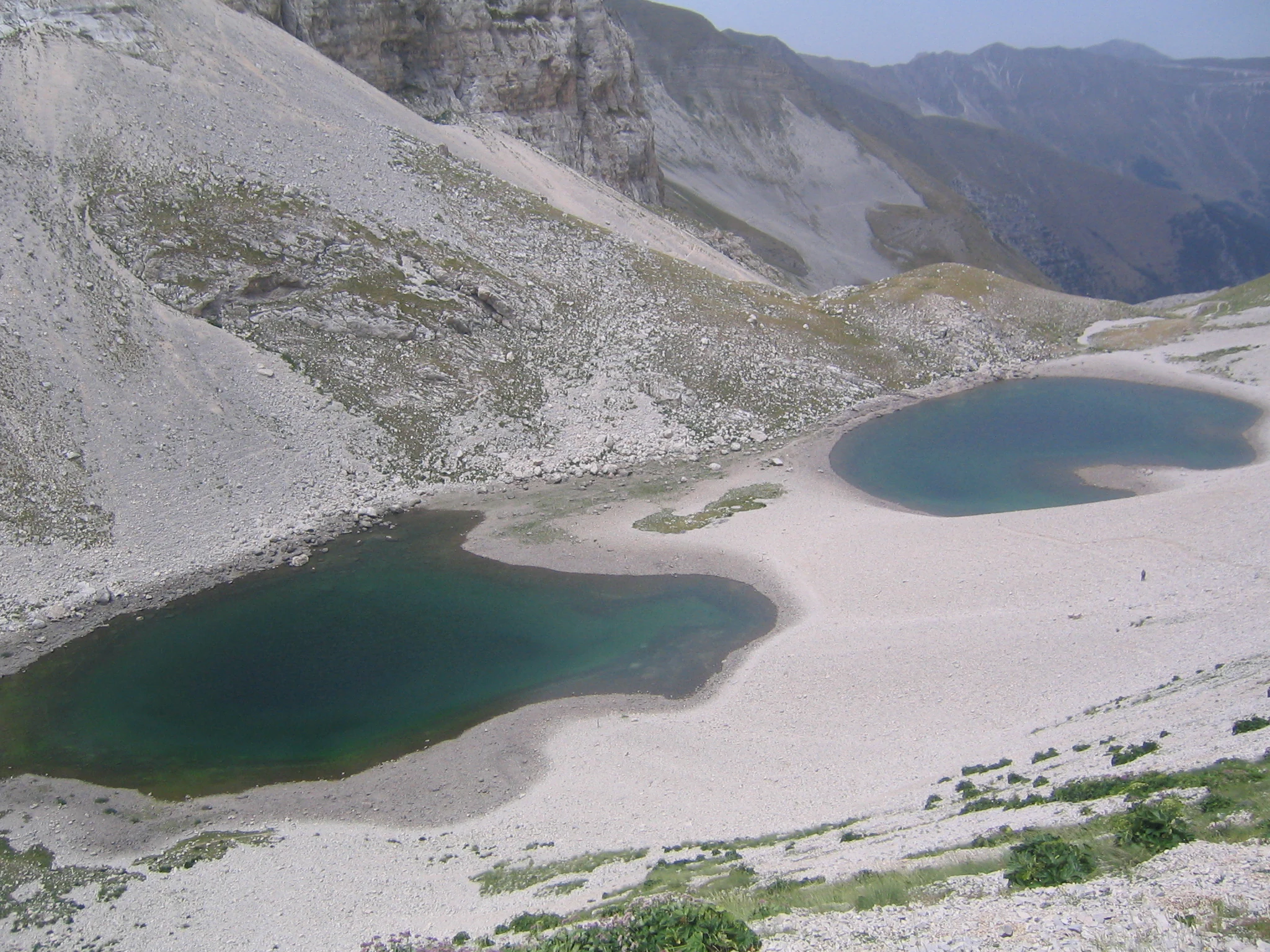 Two turquoise lakes surrounded by rocky mountain slopes with sparse vegetation