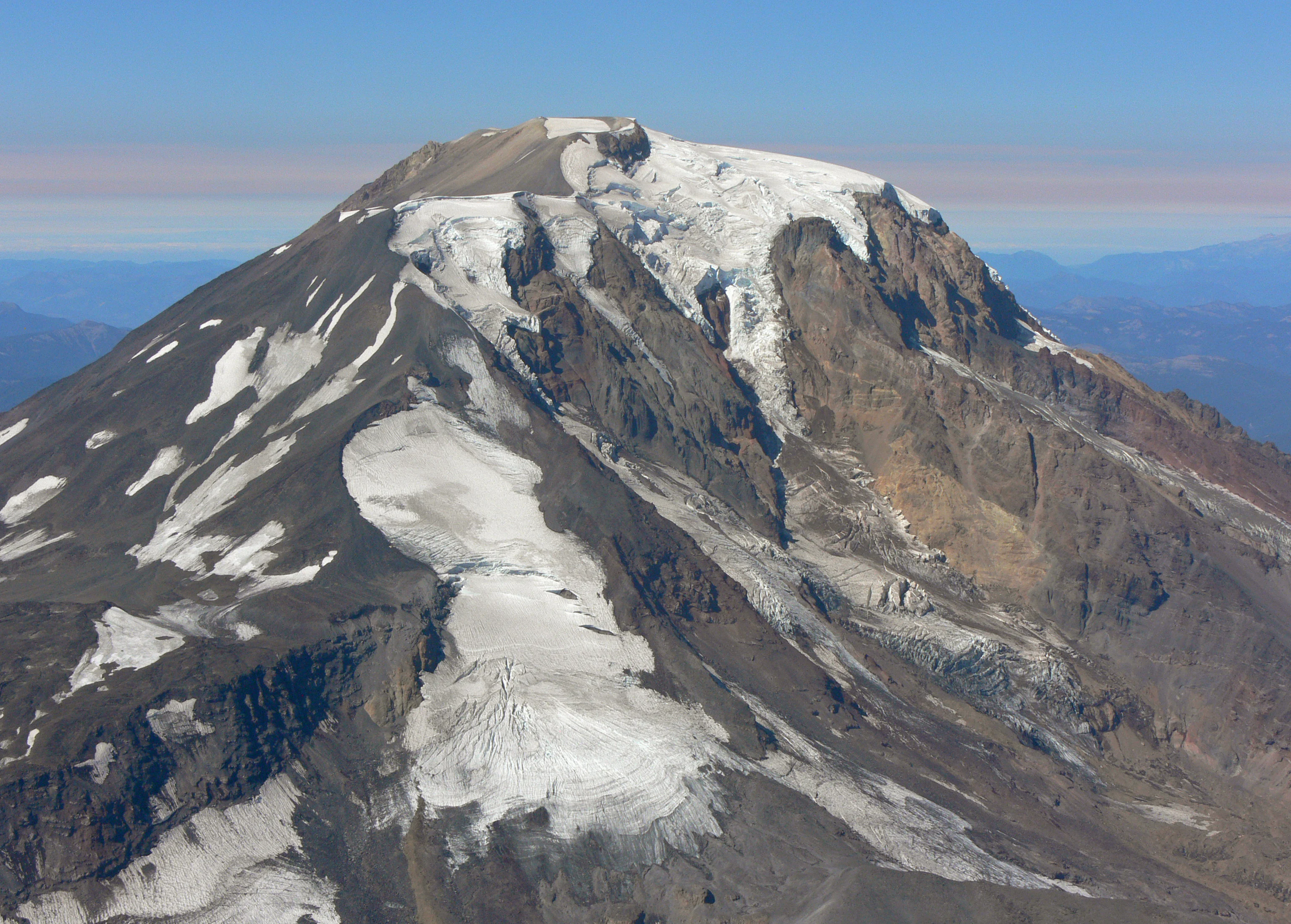 An aerial view of the snow-covered summit and glaciated slopes of Mount Adams, Washington.