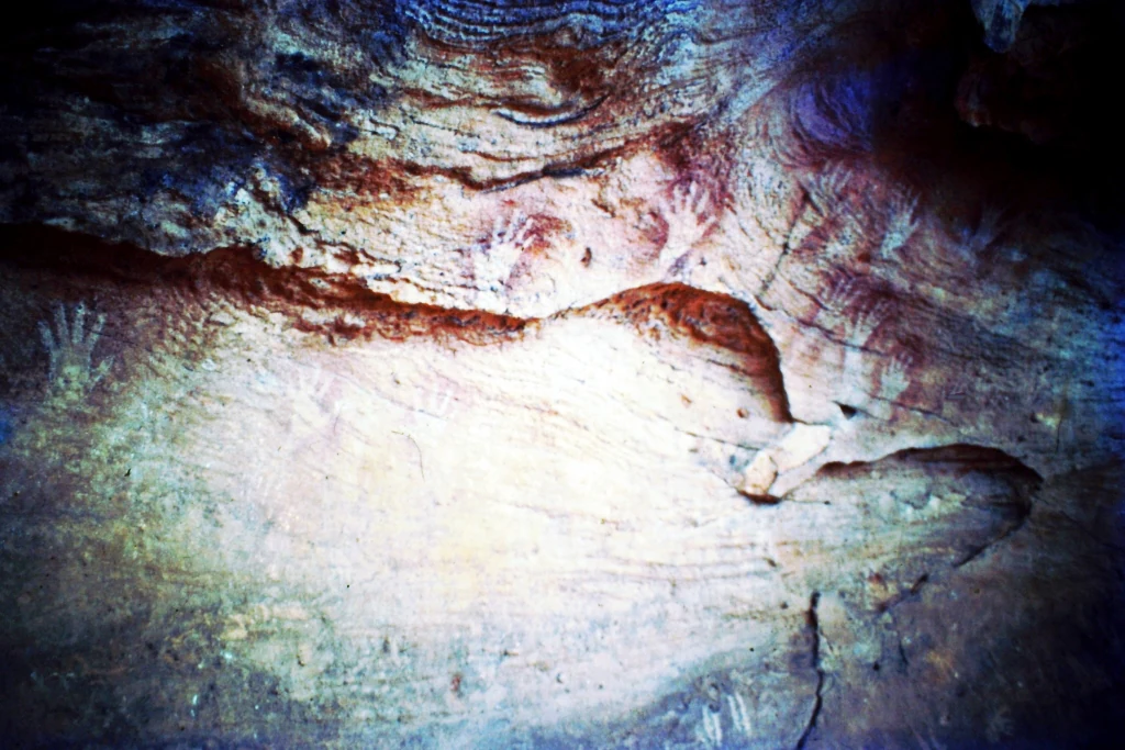 Rock overhang with hand stencil visible on the surface