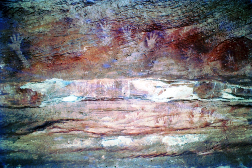 Aboriginal rock art depicting hand stencils and figures on a rocky wall in Mutawintji National Park