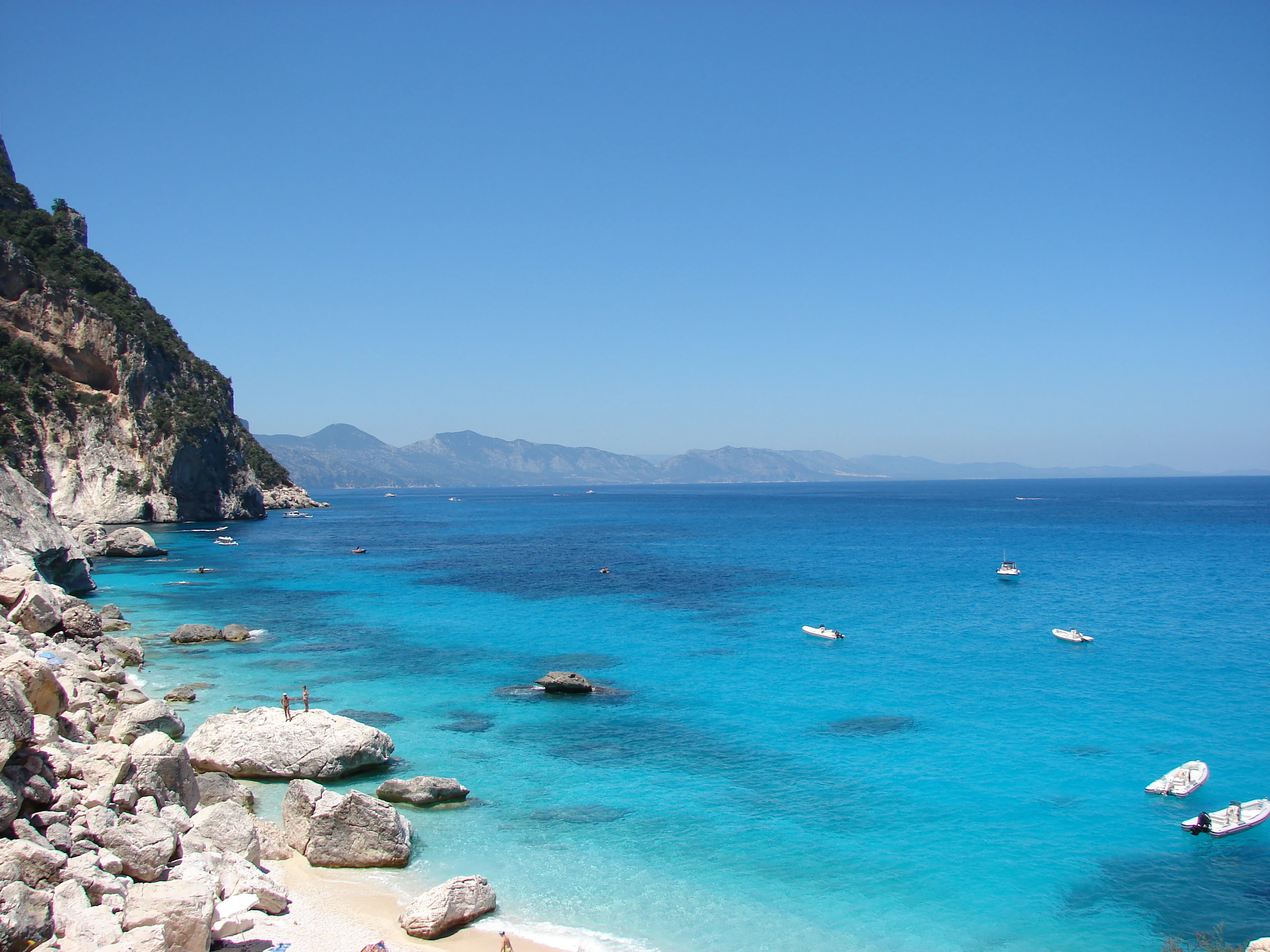 Rocky beach with clear blue water and mountainous coastline