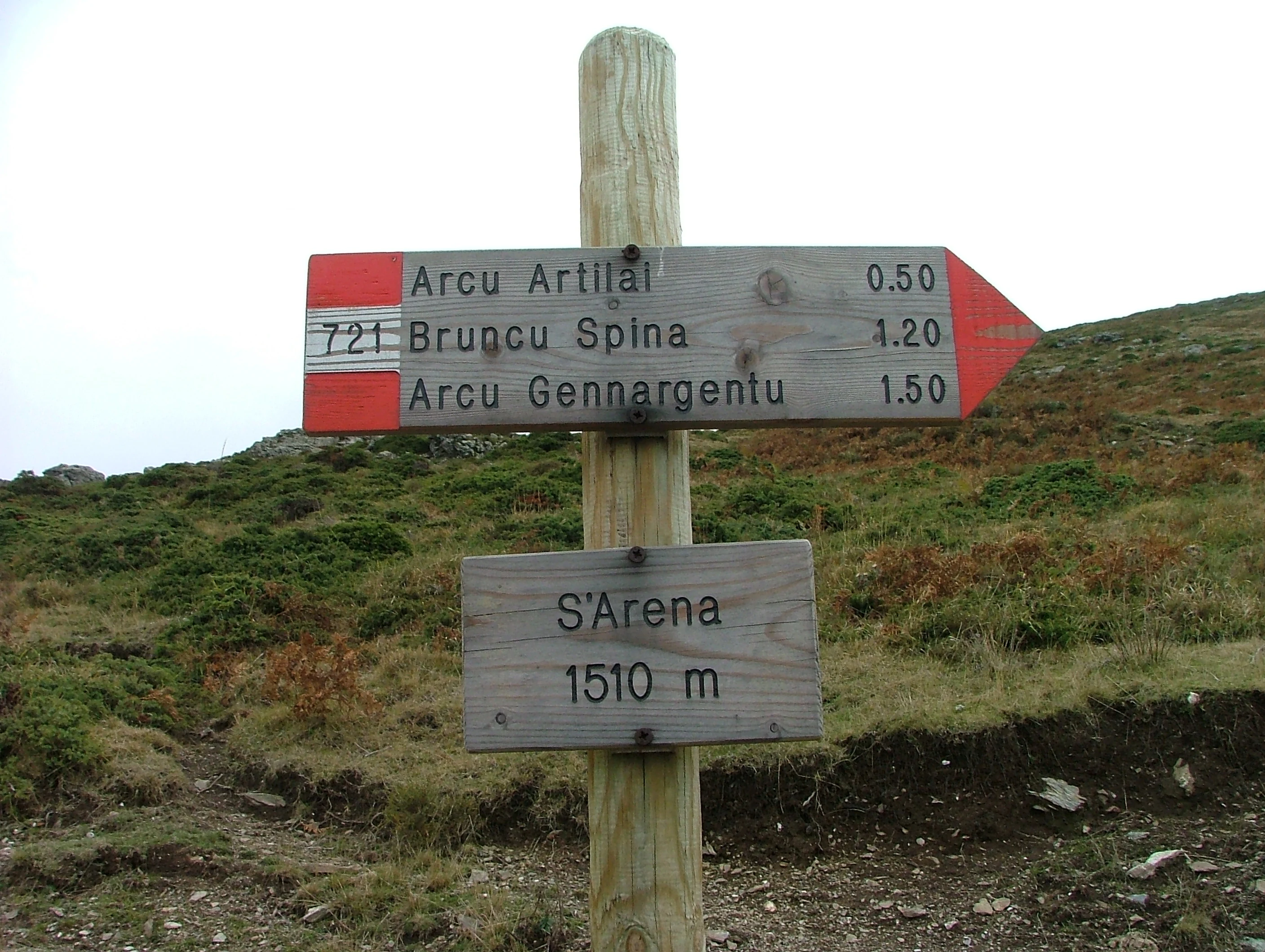 Wooden signpost with directional arrows pointing to Arcu Artial, Brunco Spina, and Arcu Gennargentu, with elevation marker S'Arena 1510 m