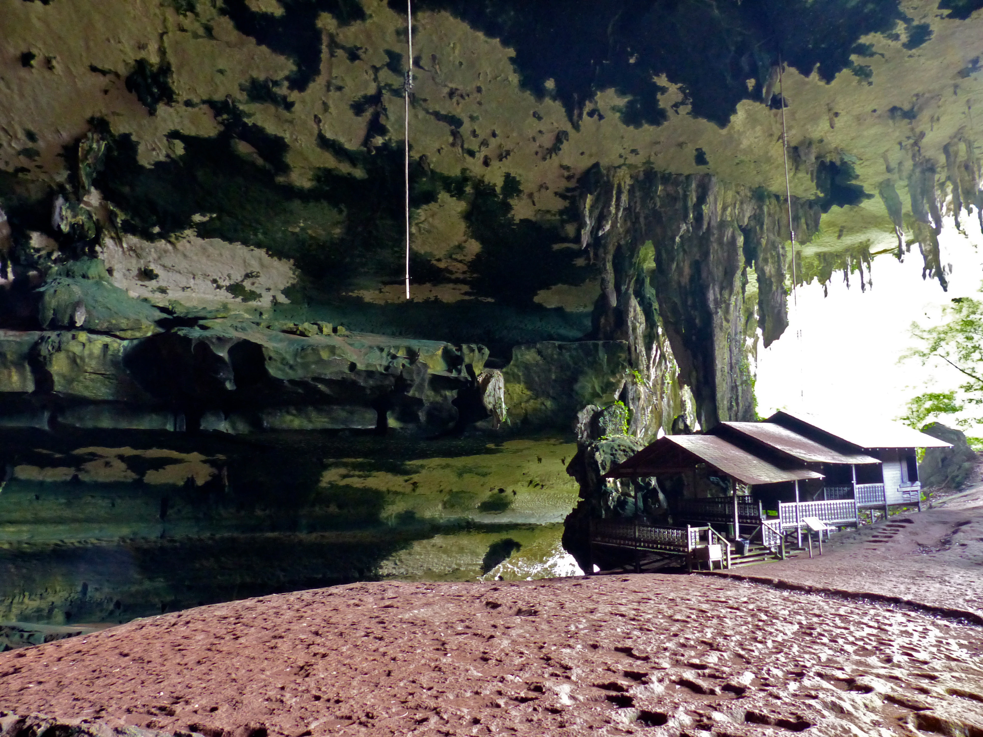 Interior view of the Great Cave showing stalactites, rocky walls, and a wooden visitor structure with a walkway