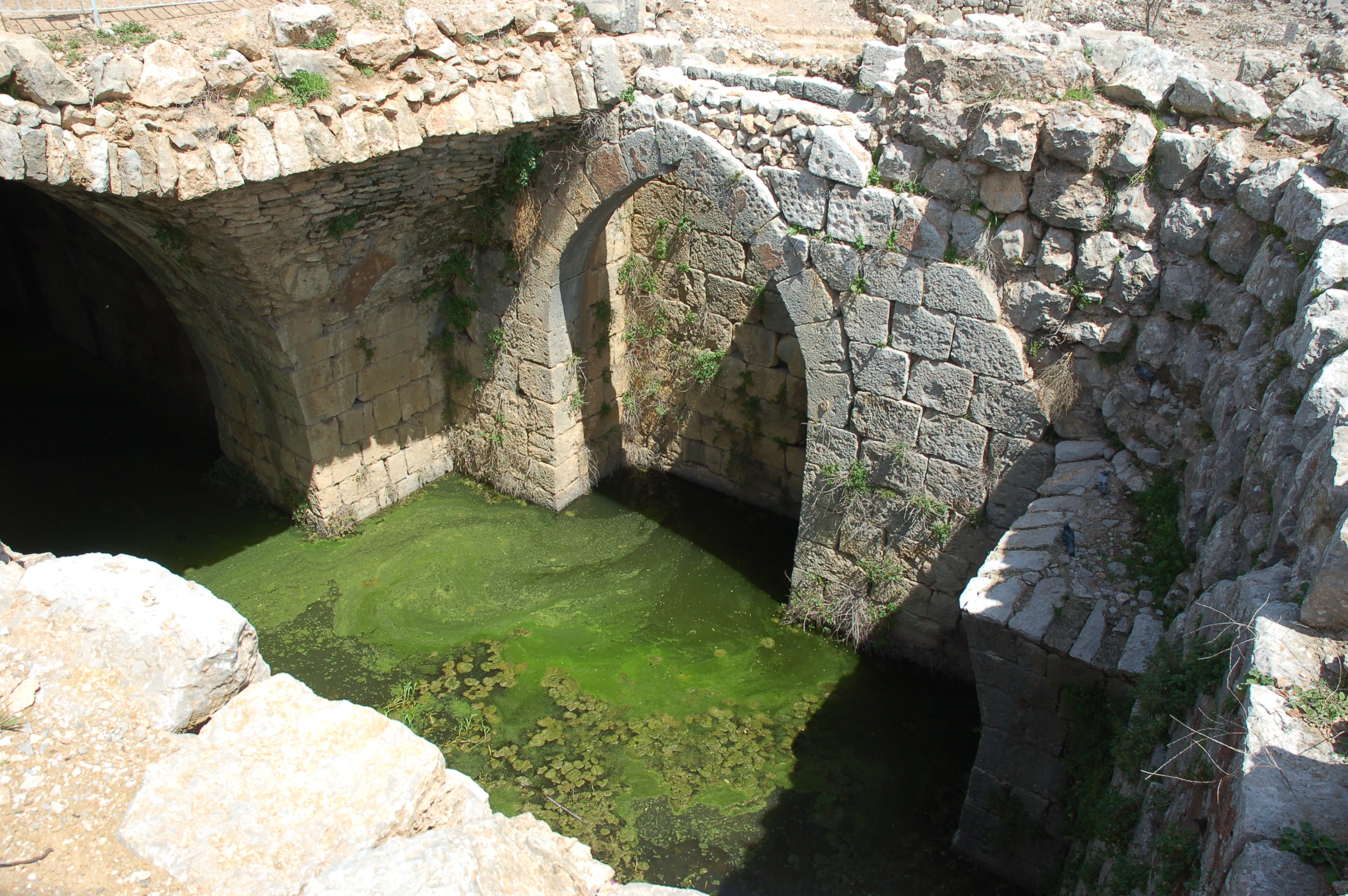 Stone arches of Nimrod Fortress with green water in a moat