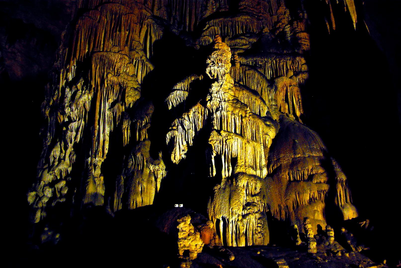 Stalactites and stalagmites inside Manita peć cave with artificial lighting