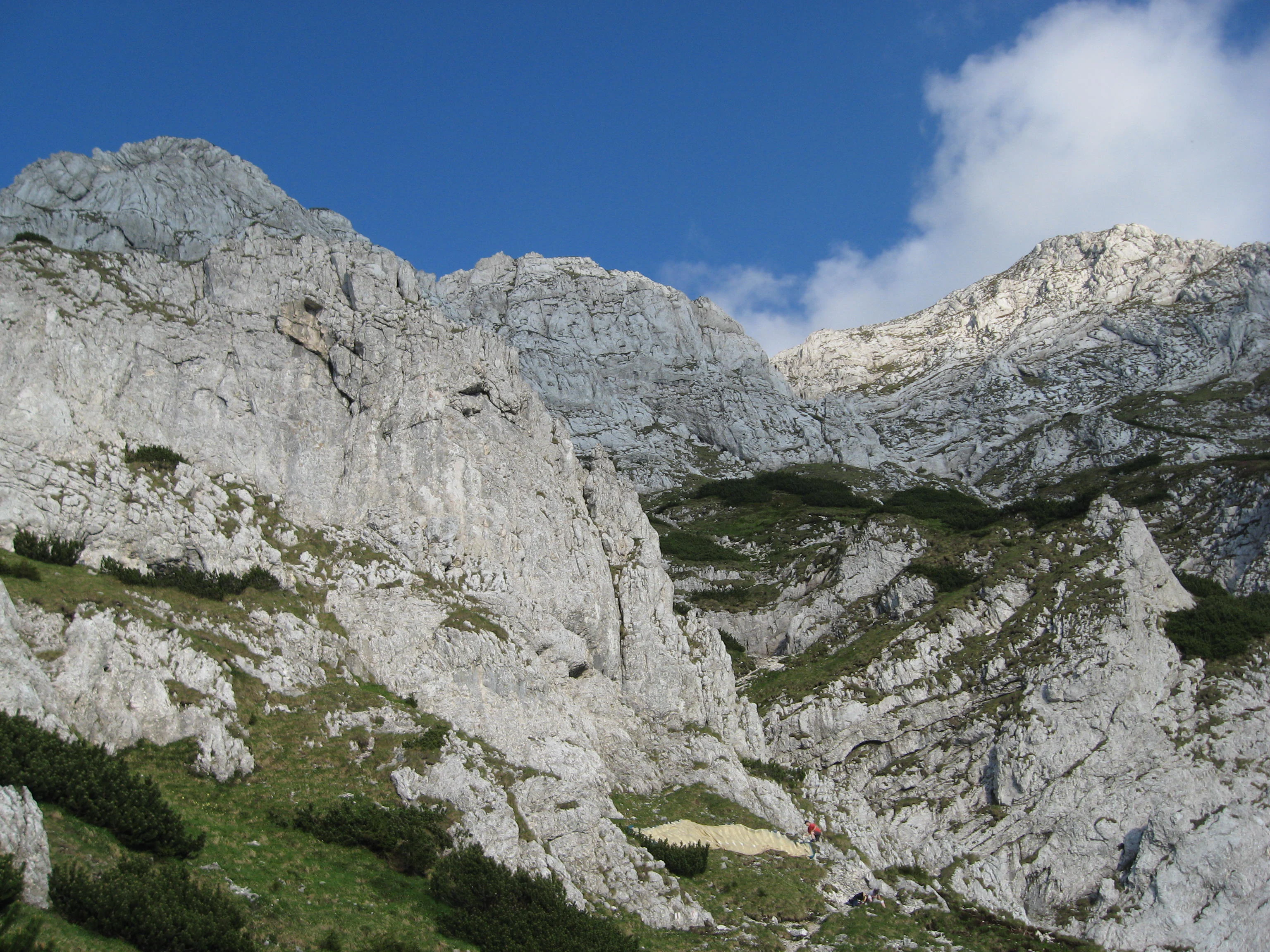 Rocky mountain peaks and ridges with green vegetation under a clear blue sky