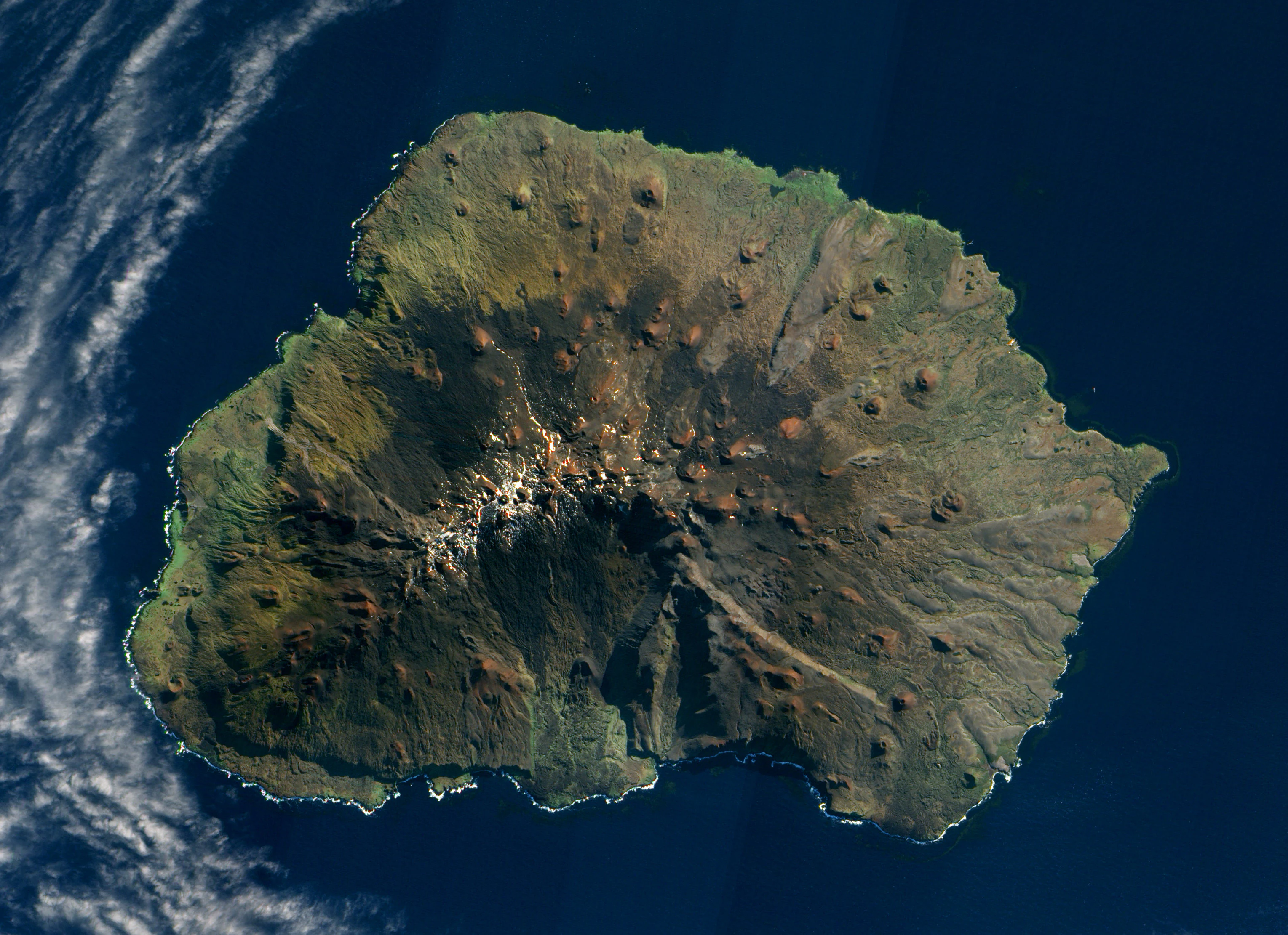 Satellite image showing the circular, volcanic island of Marion Island surrounded by the dark blue Indian Ocean.