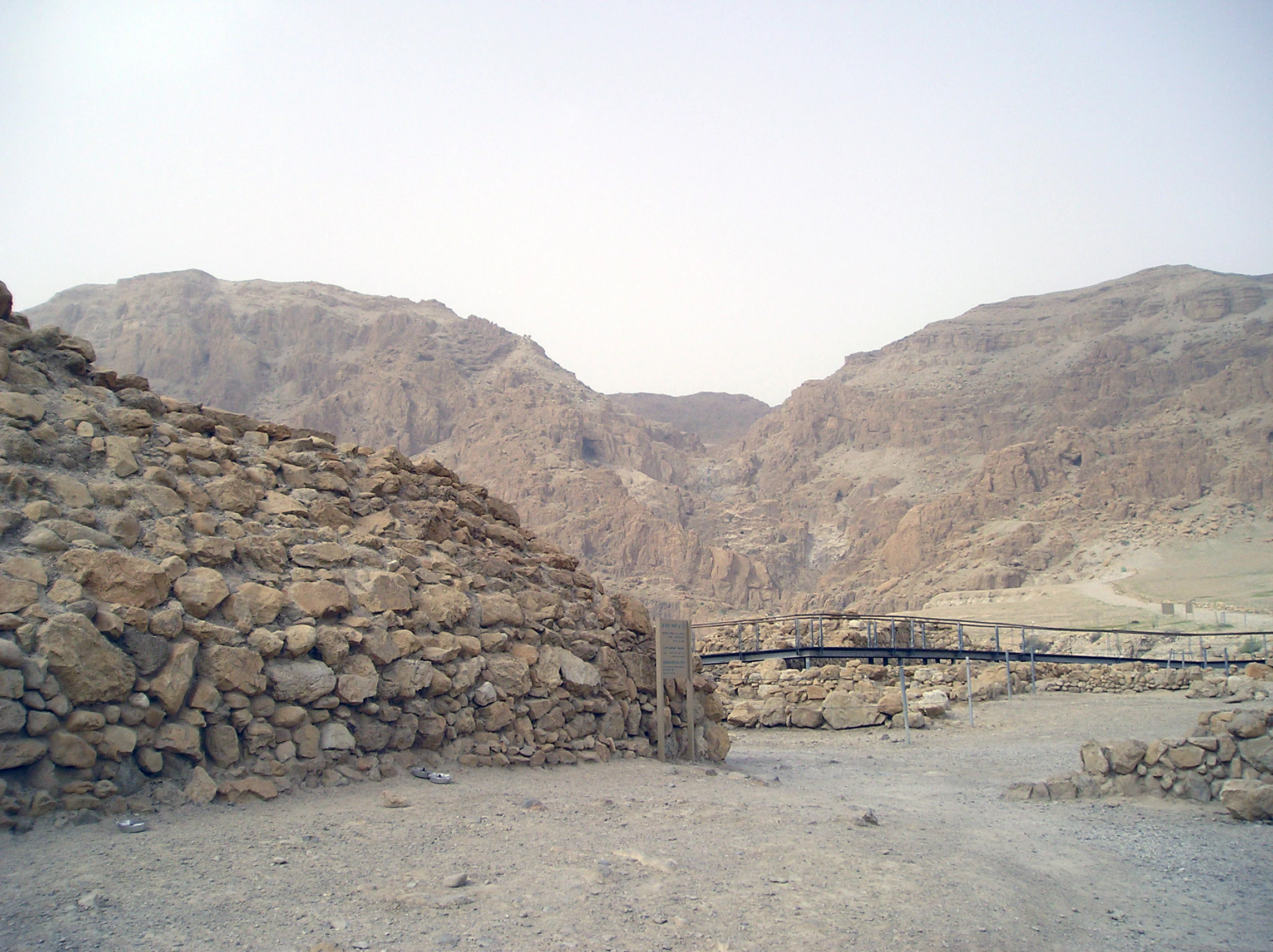 Stone ruins and dry landscape with mountains in the background