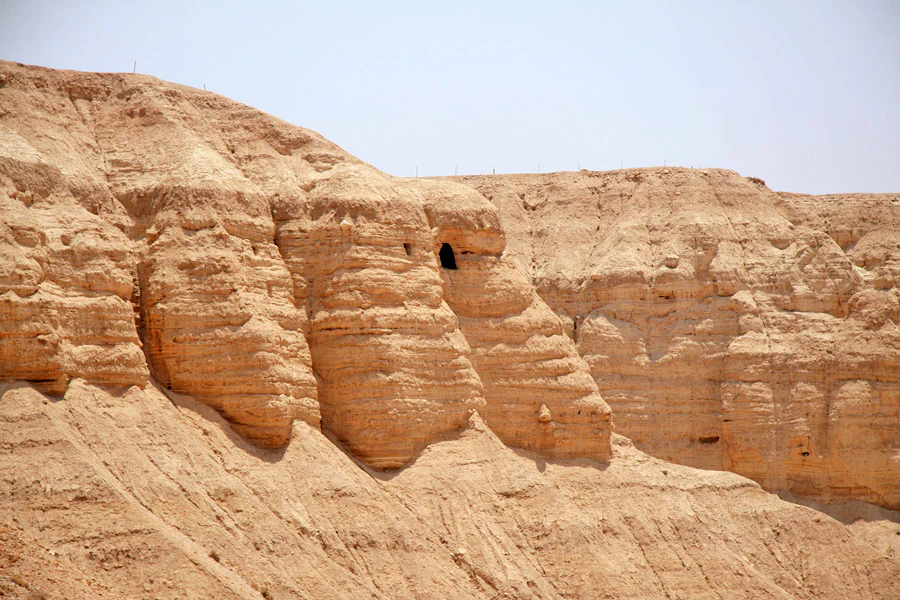 Rocky desert cliffs with visible cave openings at Qumran National Park