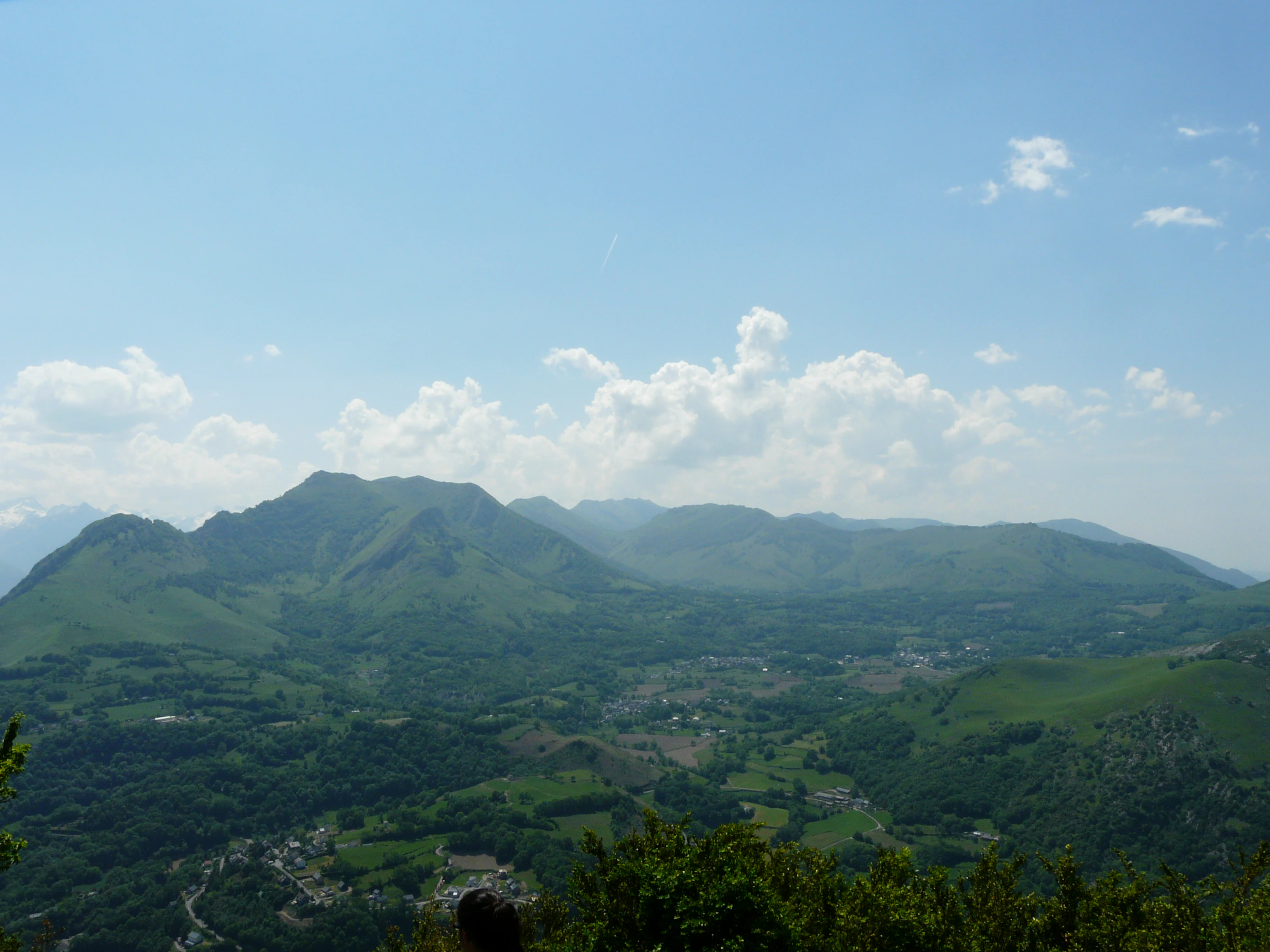 Panoramic landscape view of the green Pibeste mountain range and Batsurguere valley under a blue sky with scattered clouds.