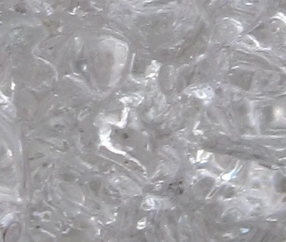 Extremely close-up view of clear, crystalline glacial ice showing intricate fractures and bubbles.