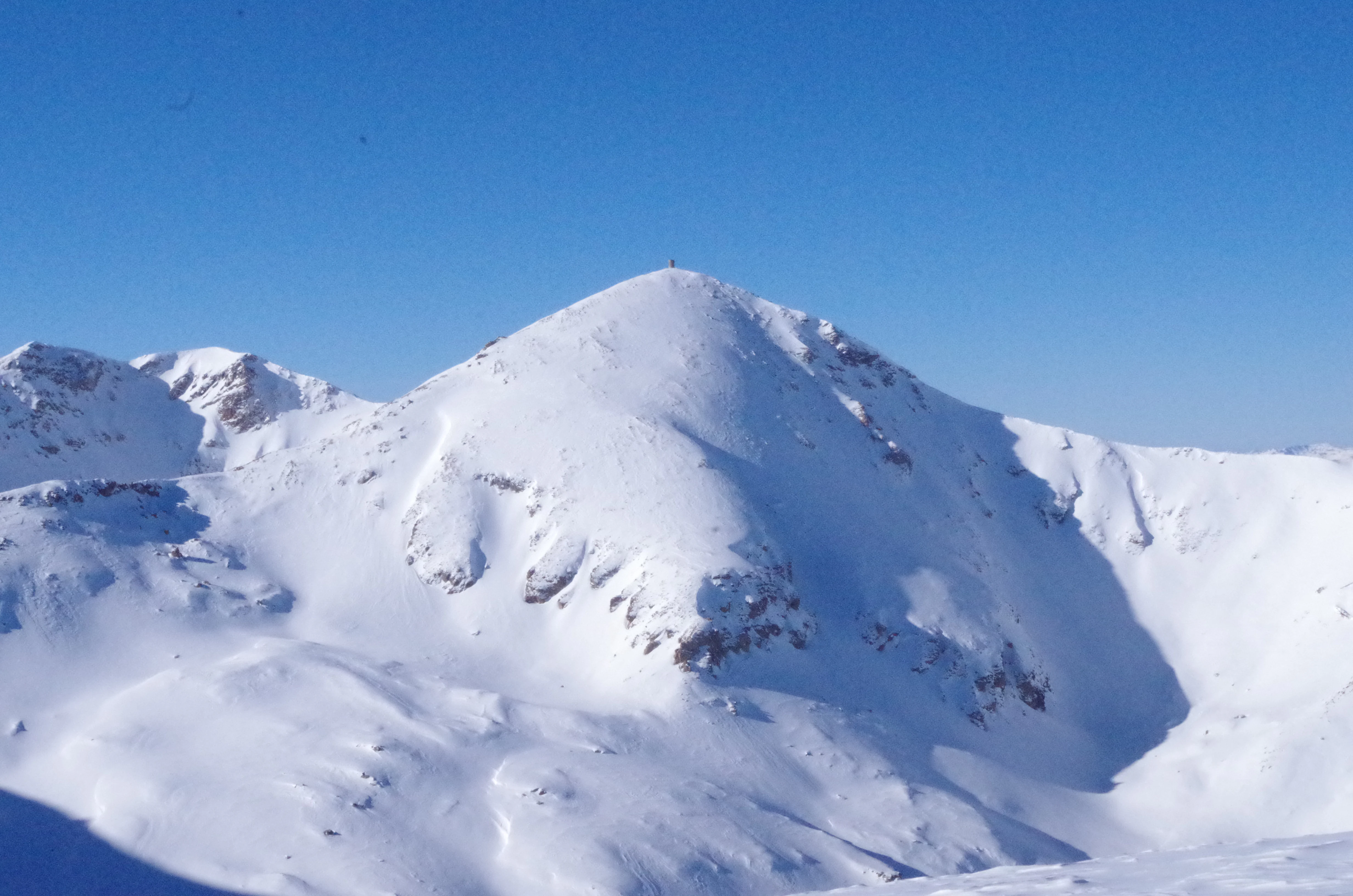 Snow-covered mountain peak with clear blue sky