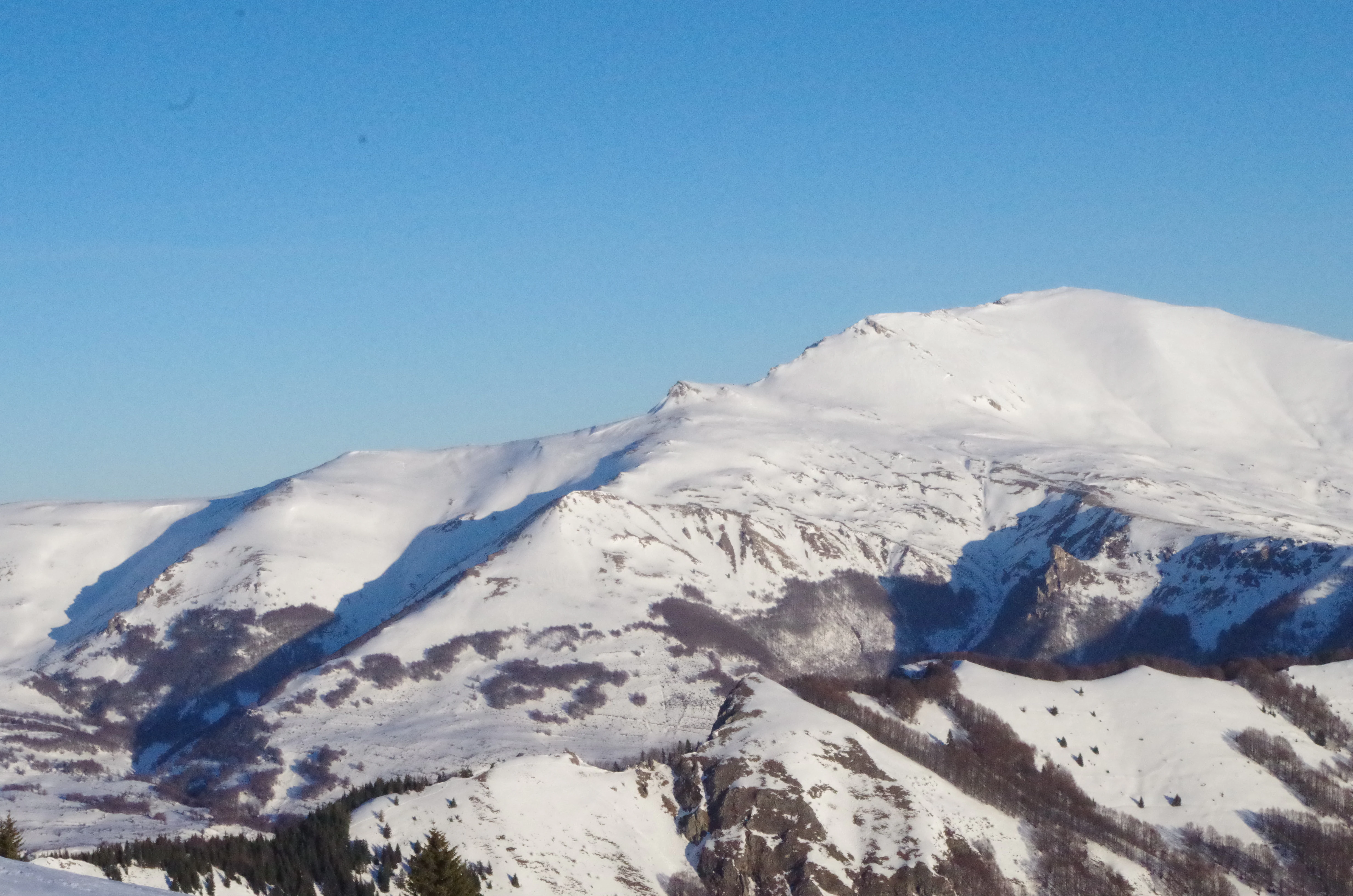 Snow-covered mountain peaks in Šar Mountains range with clear blue sky