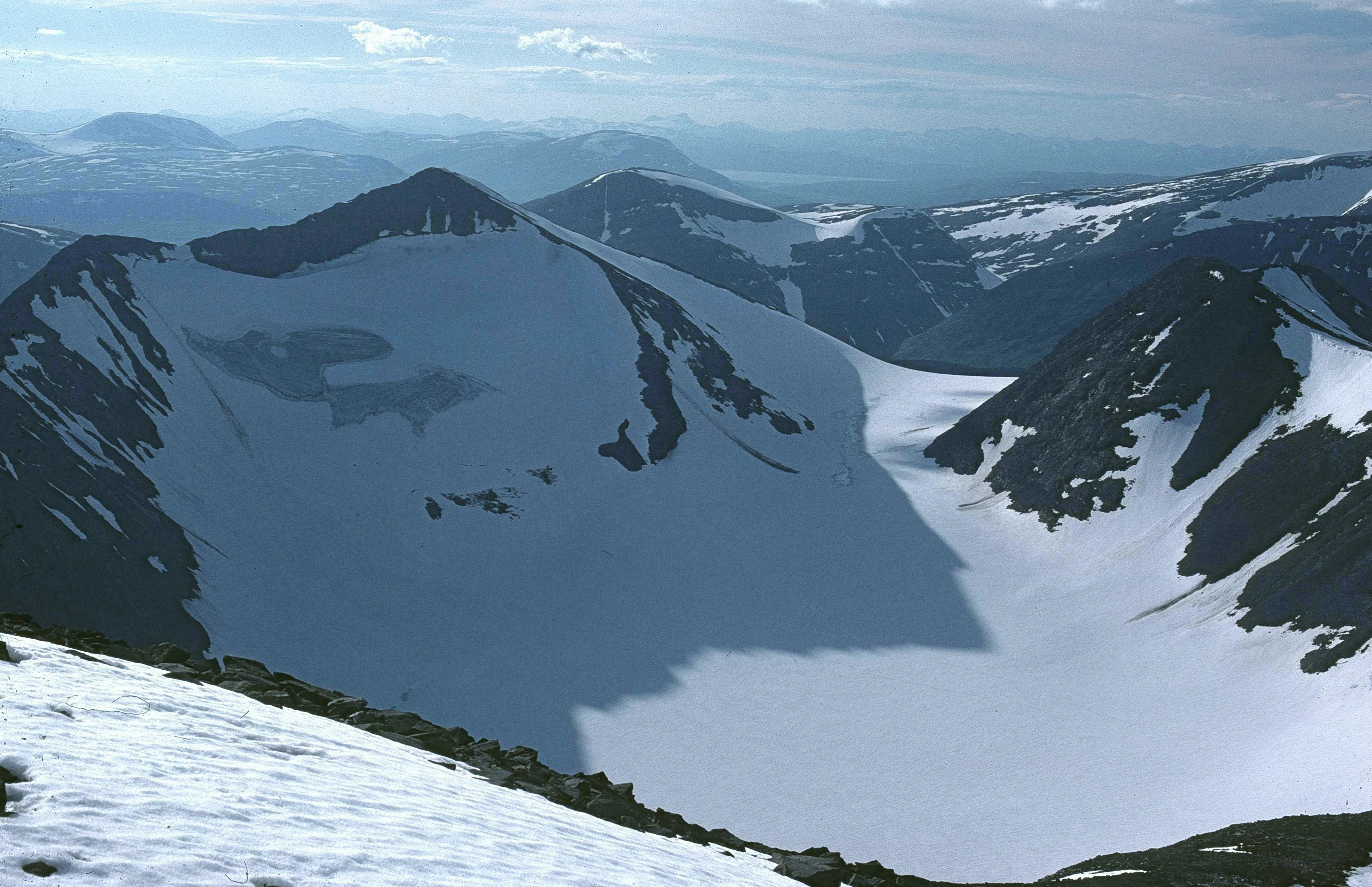 Wide view of snow-capped mountains and a glacier in Sarek National Park, Sweden
