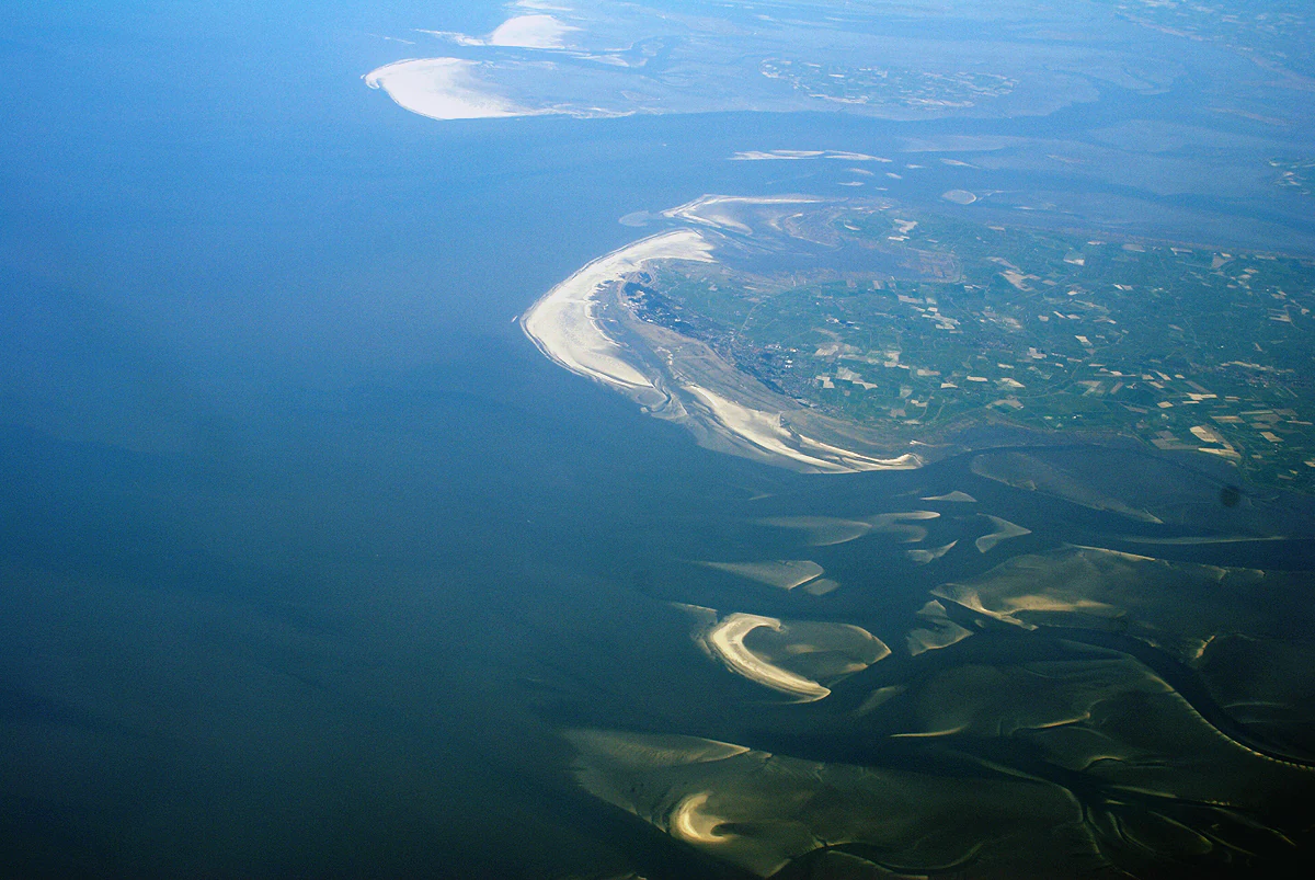 Aerial view of coastal landscape with visible mudflats, sandbanks, and waterways