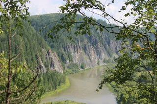 River winding through mountainous landscape with dense forests, viewed from an observation deck