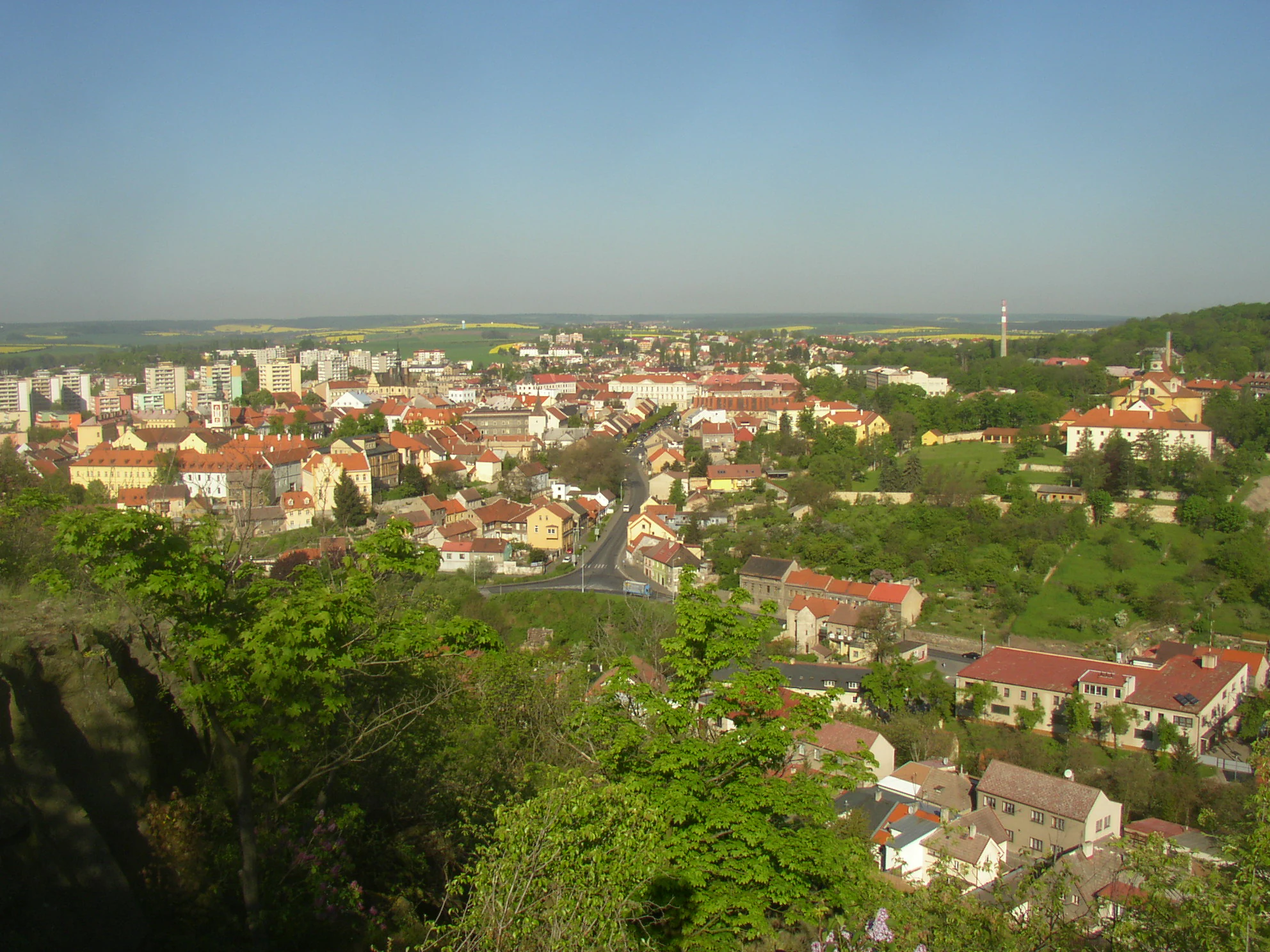 An elevated panoramic view looking down over the town of Slany, Czech Republic, from the wooded summit of Slanska hora.