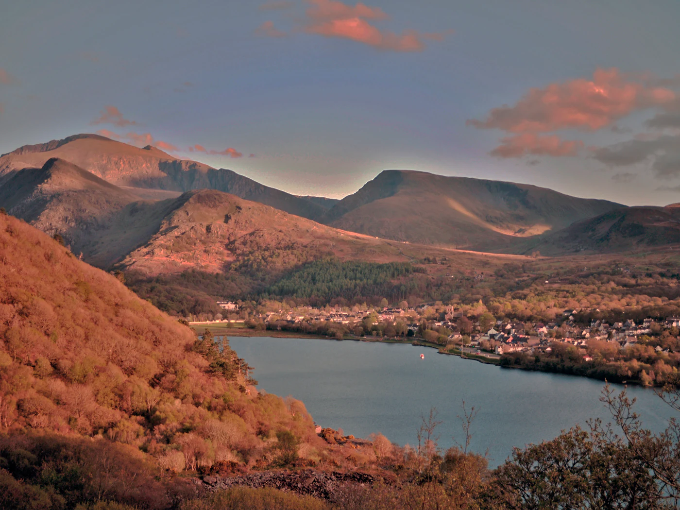 Sunset over a lake, village, and mountainous landscape in Snowdonia National Park