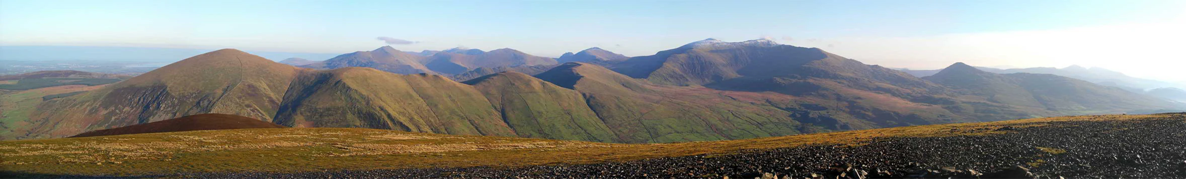 Panoramic view of rolling mountain hills in Snowdonia National Park under a clear sky